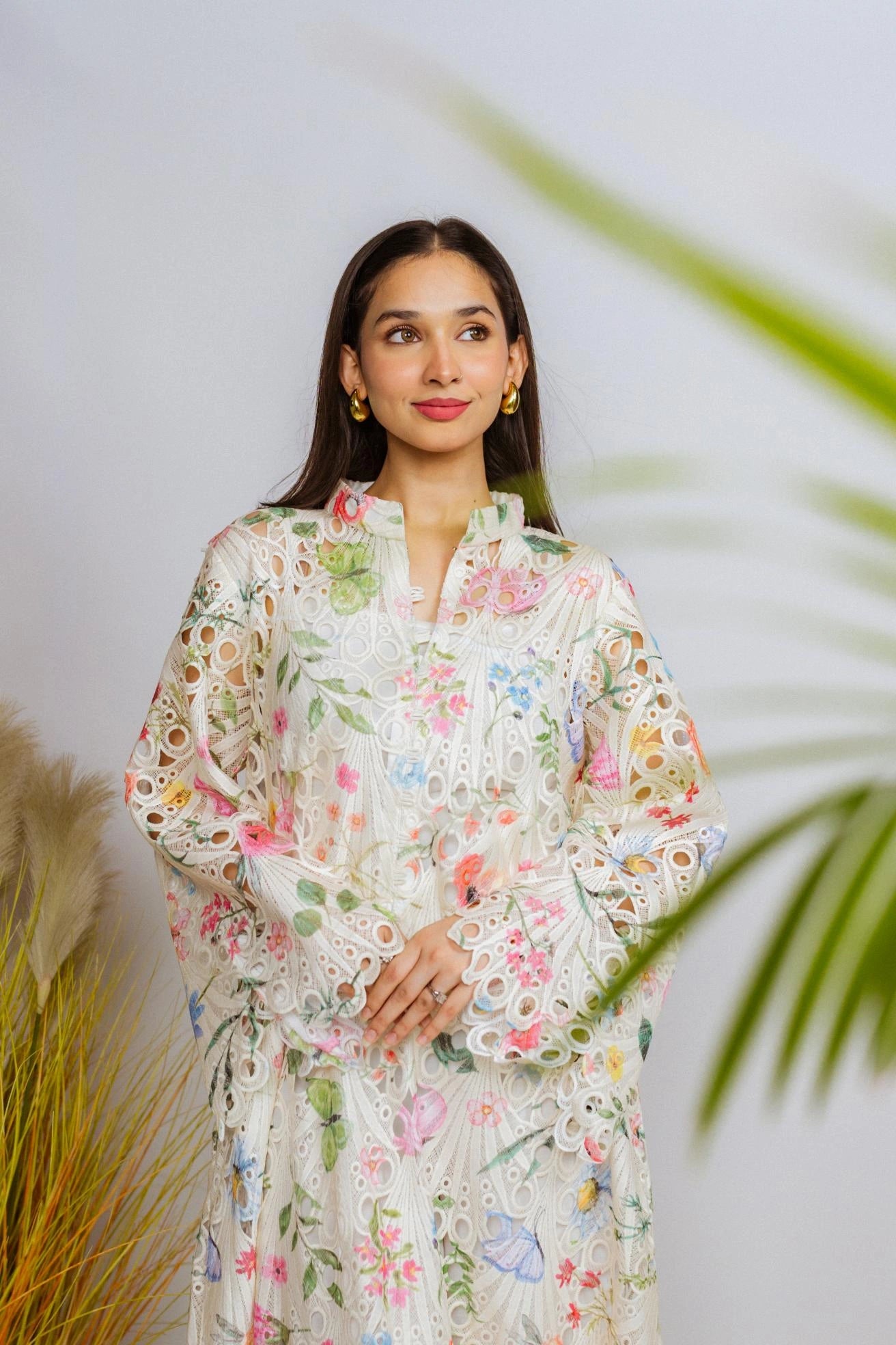 Multi-floral cutwork kaftan-style shirt with flared sleeves, featuring a vibrant design and relaxed, flowy fit for comfort.