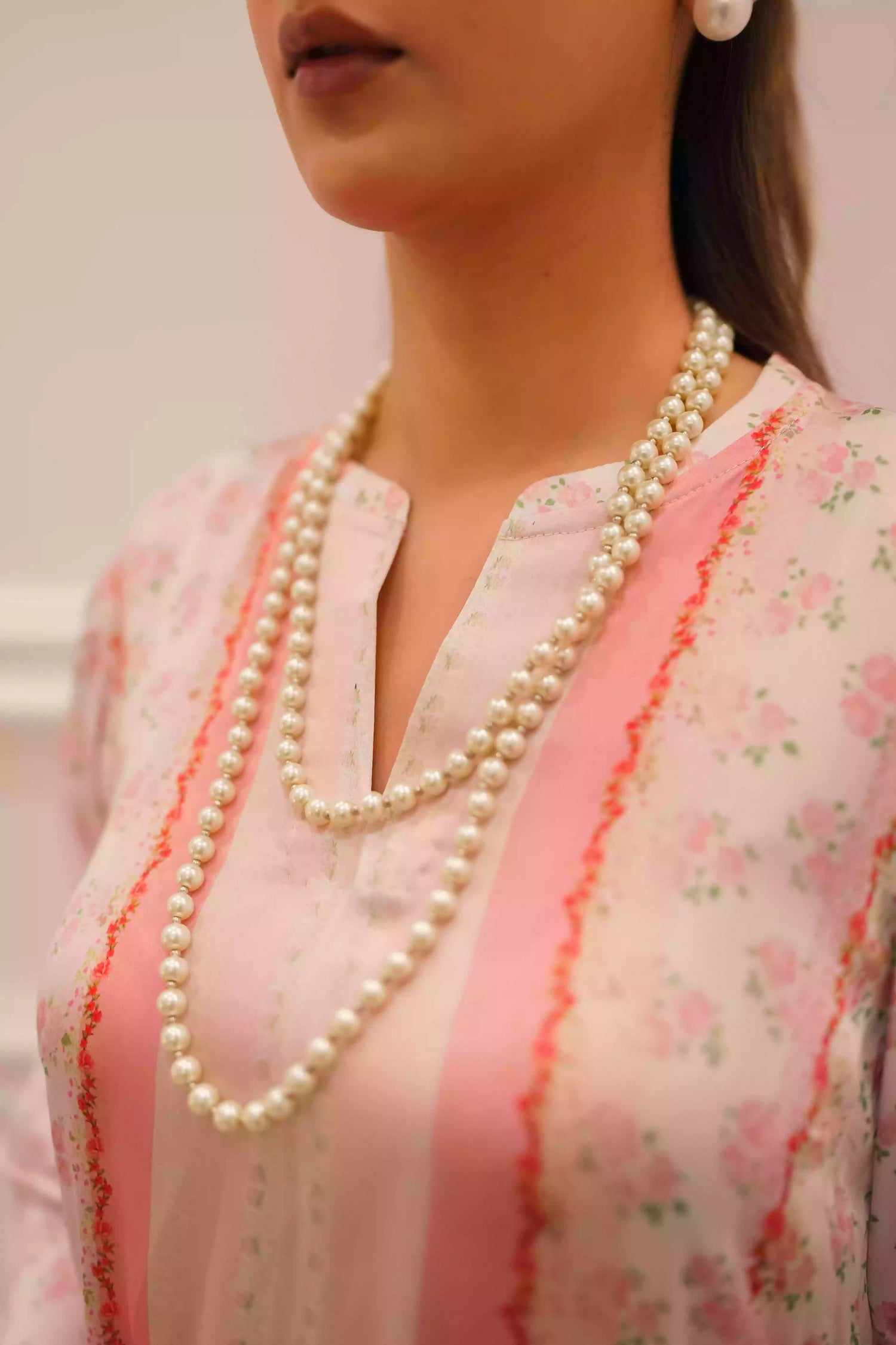 White and blush-pink silk kurta with delicate floral motifs and subtle hand-finished embellishments, featuring a lightweight, flowing drape that creates an elegant silhouette, ideal for Eid and festive daytime celebrations.