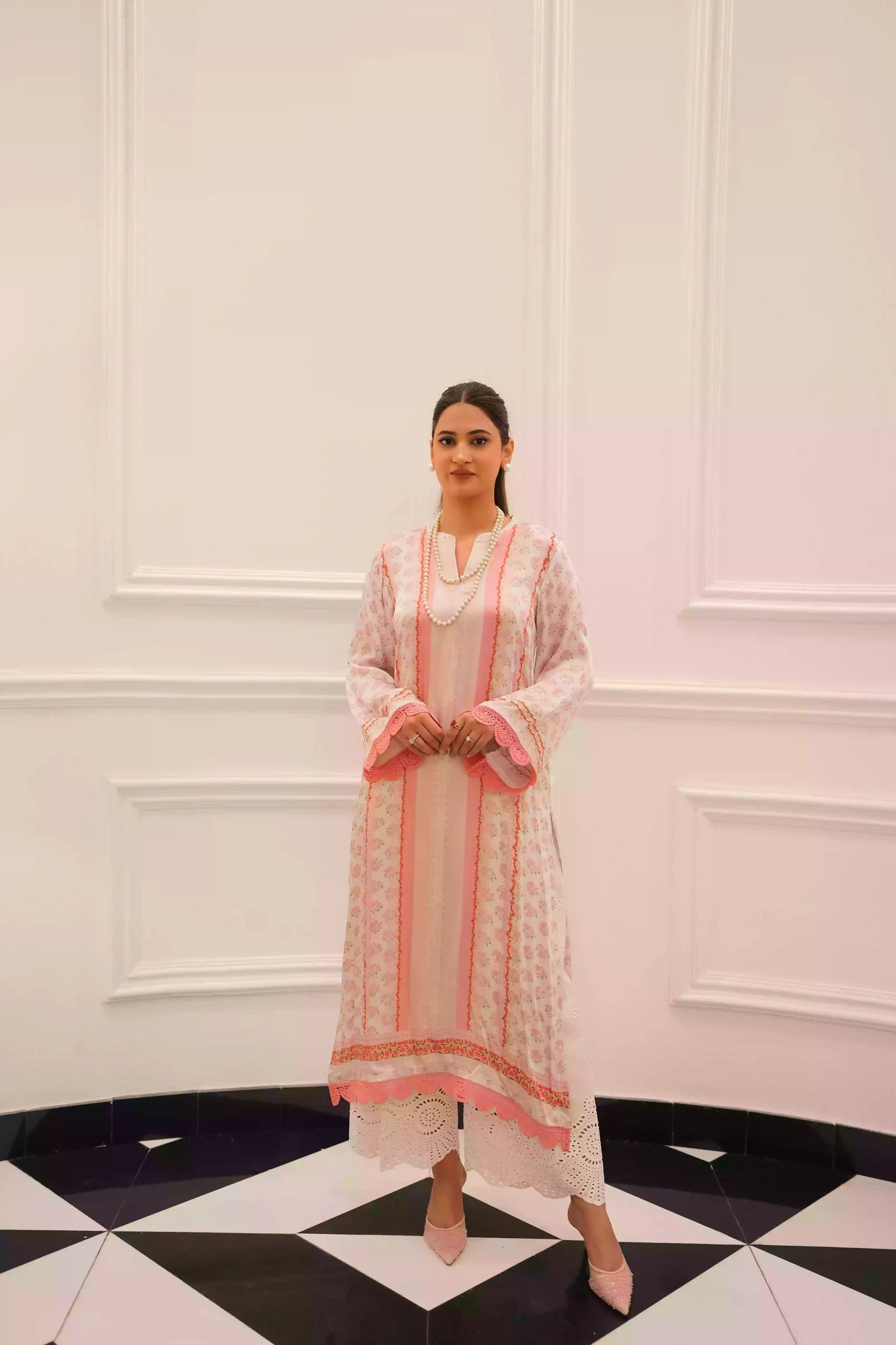 White and blush-pink silk kurta with delicate floral motifs and subtle hand-finished embellishments, featuring a lightweight, flowing drape that creates an elegant silhouette, ideal for Eid and festive daytime celebrations.