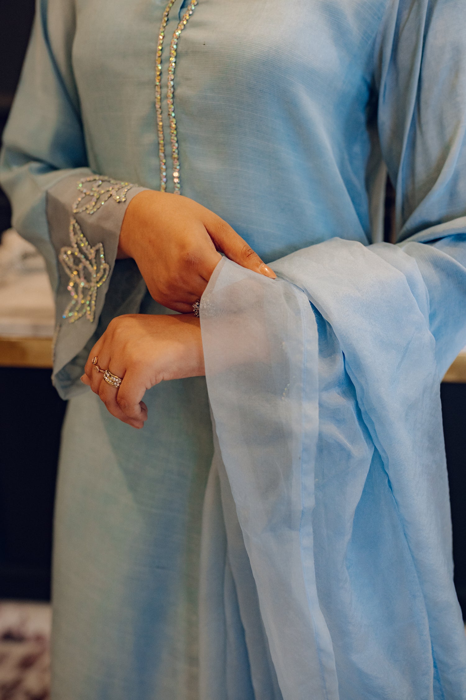 A flowing ice blue dress adorned with rhinestones showcasing elegance and style.