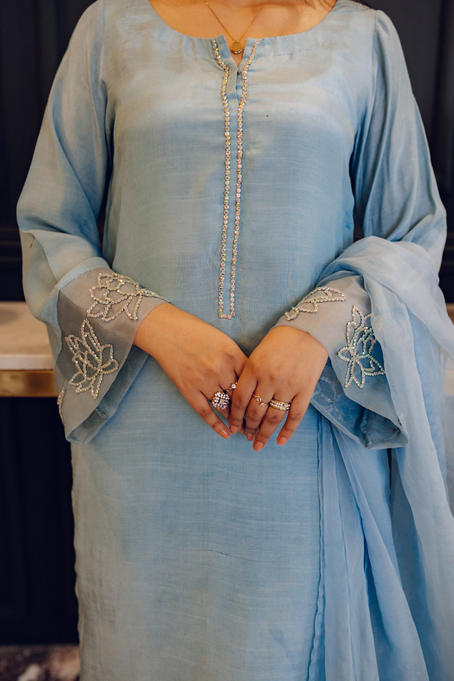 A flowing ice blue dress adorned with rhinestones showcasing elegance and style.