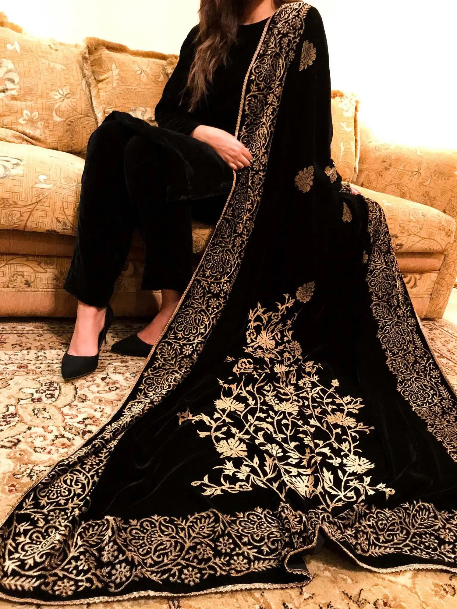 A black and gold shawl, showcasing intricate floral motifs, exuding elegance and warmth for festive occasions.