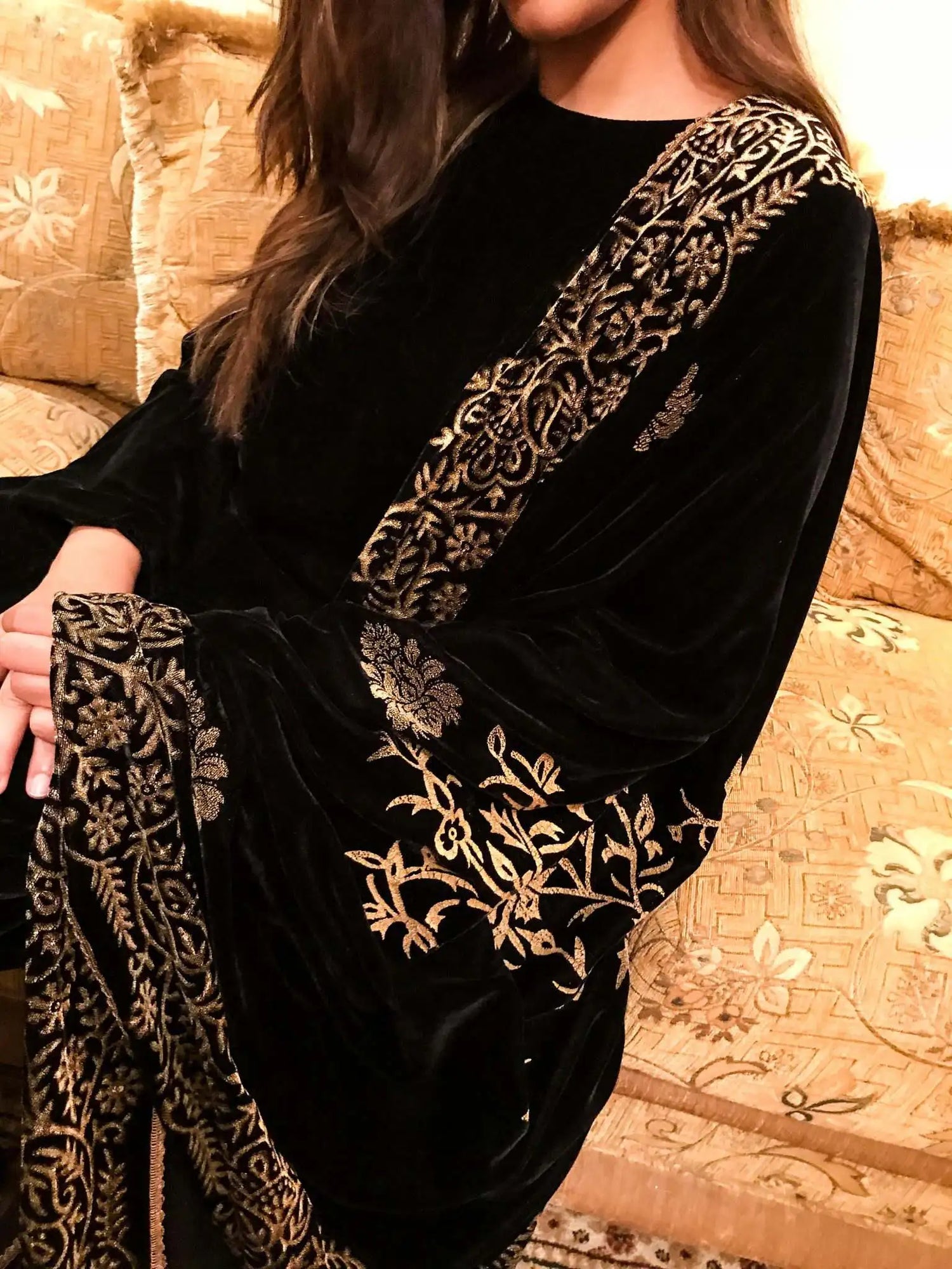 A black and gold shawl, showcasing intricate floral motifs, exuding elegance and warmth for festive occasions.