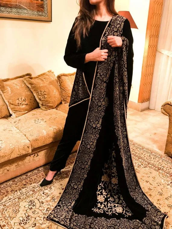 A black and gold shawl, showcasing intricate floral motifs, exuding elegance and warmth for festive occasions.