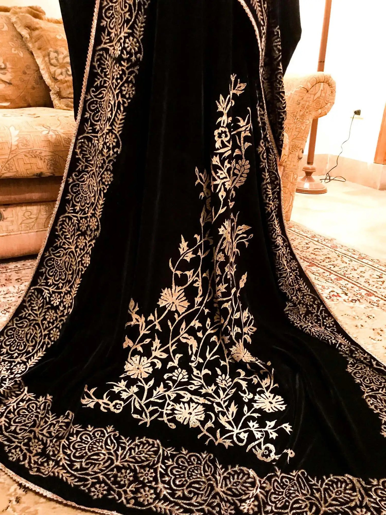 A black and gold shawl, showcasing intricate floral motifs, exuding elegance and warmth for festive occasions.
