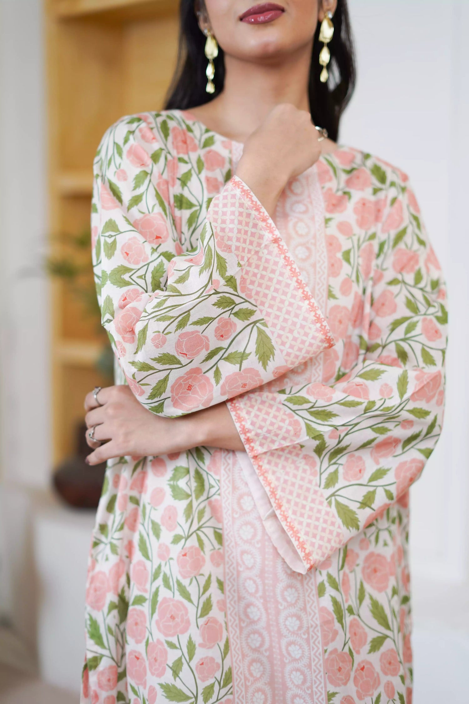 A pink and green suit featuring a floral design on cream, paired with light pink printed trousers exuding timeless elegance.