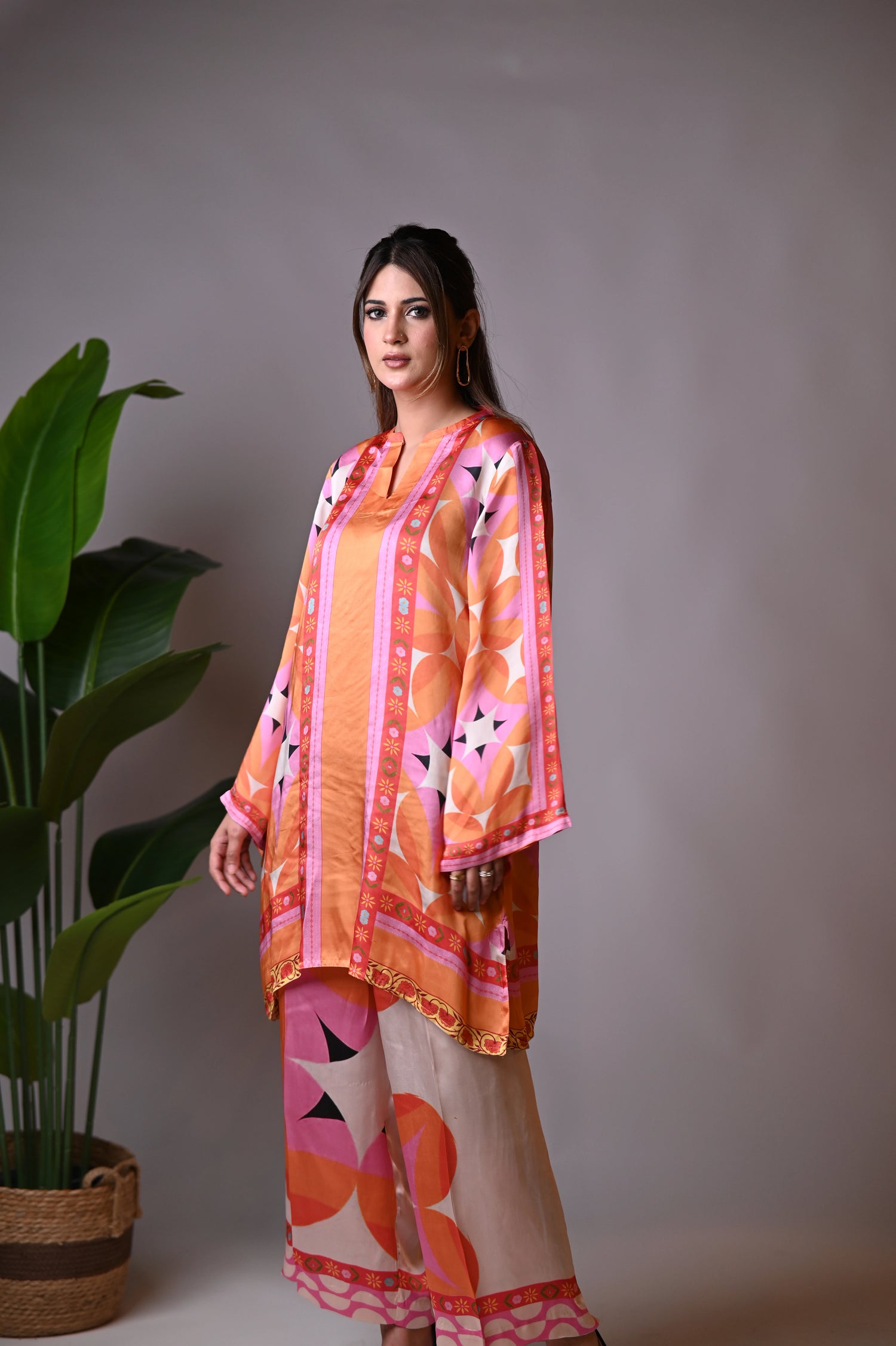 Vibrant orange silk cord set with bold circle patterns, combining fluid elegance and high-fashion comfort.