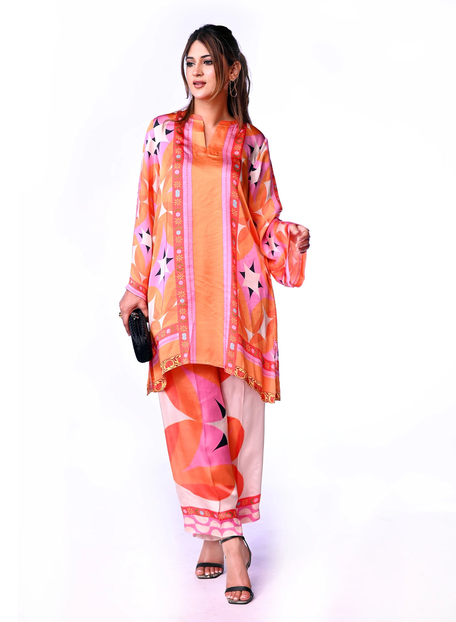 Vibrant orange silk cord set with bold circle patterns, combining fluid elegance and high-fashion comfort.