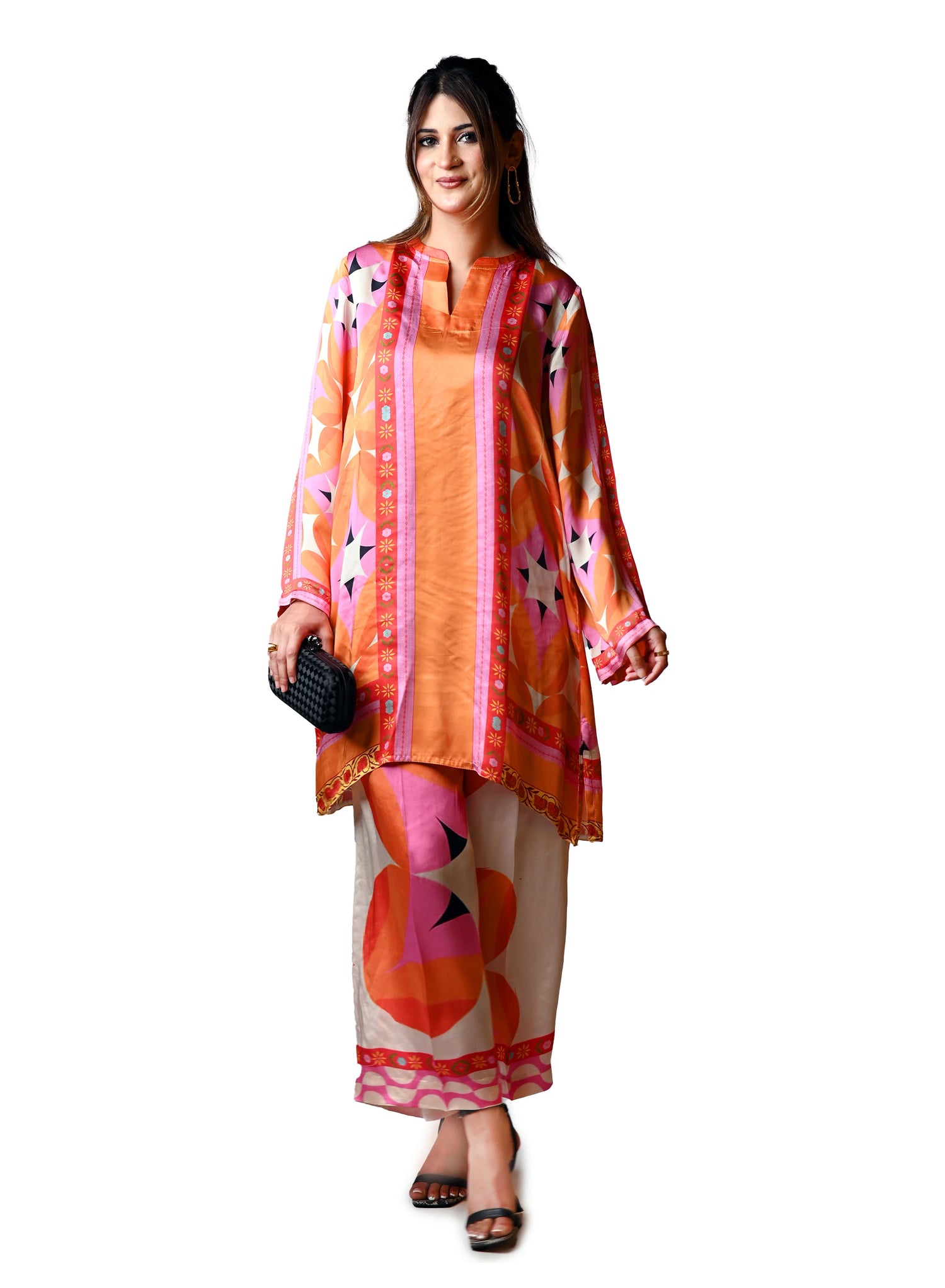 Vibrant orange silk cord set with bold circle patterns, combining fluid elegance and high-fashion comfort.