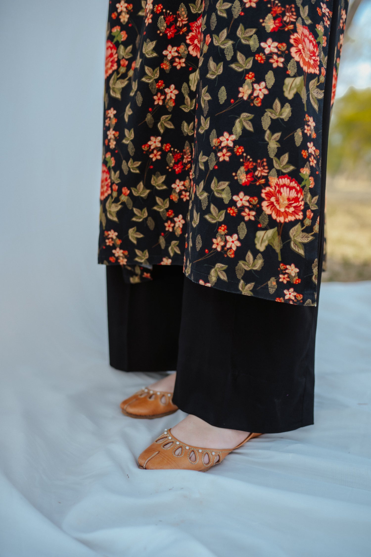 Black ethnic outfit made from soft fabric. Features gold-toned festive wear with floral patterns.