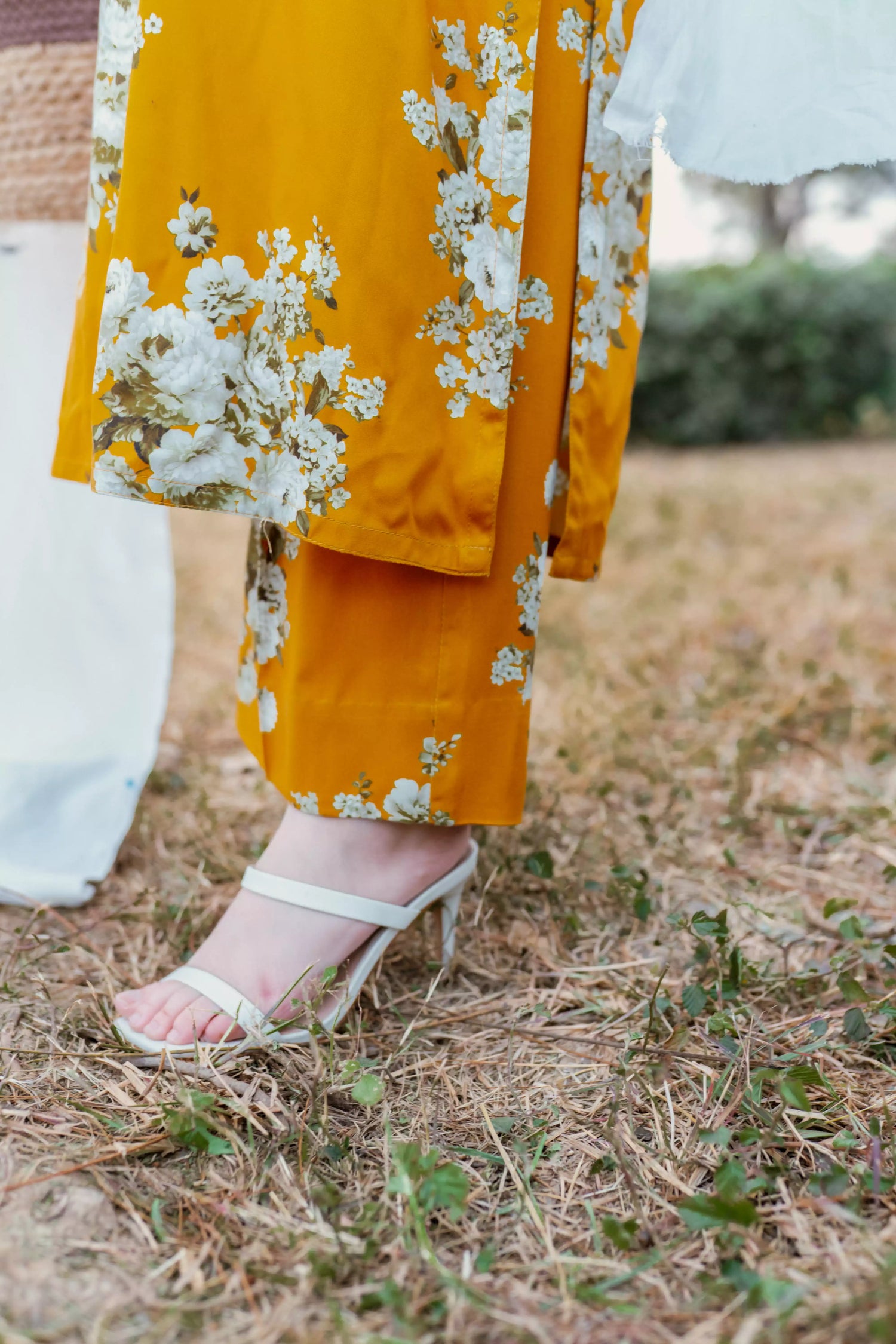 Yellow floral two-piece suit with long shirt and flared pants, styled for casual and semi-formal occasions.