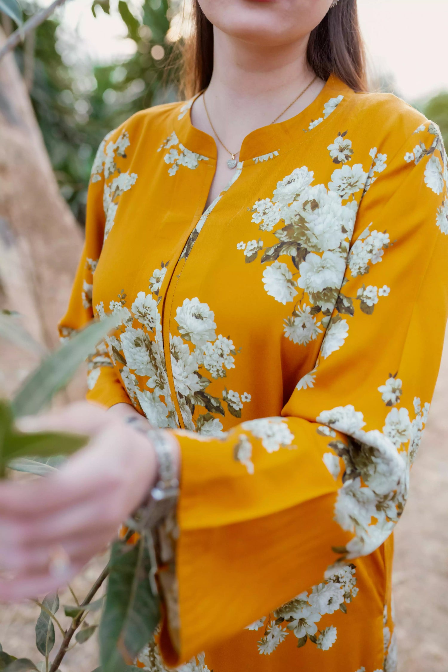 Yellow floral two-piece suit with long shirt and flared pants, styled for casual and semi-formal occasions.