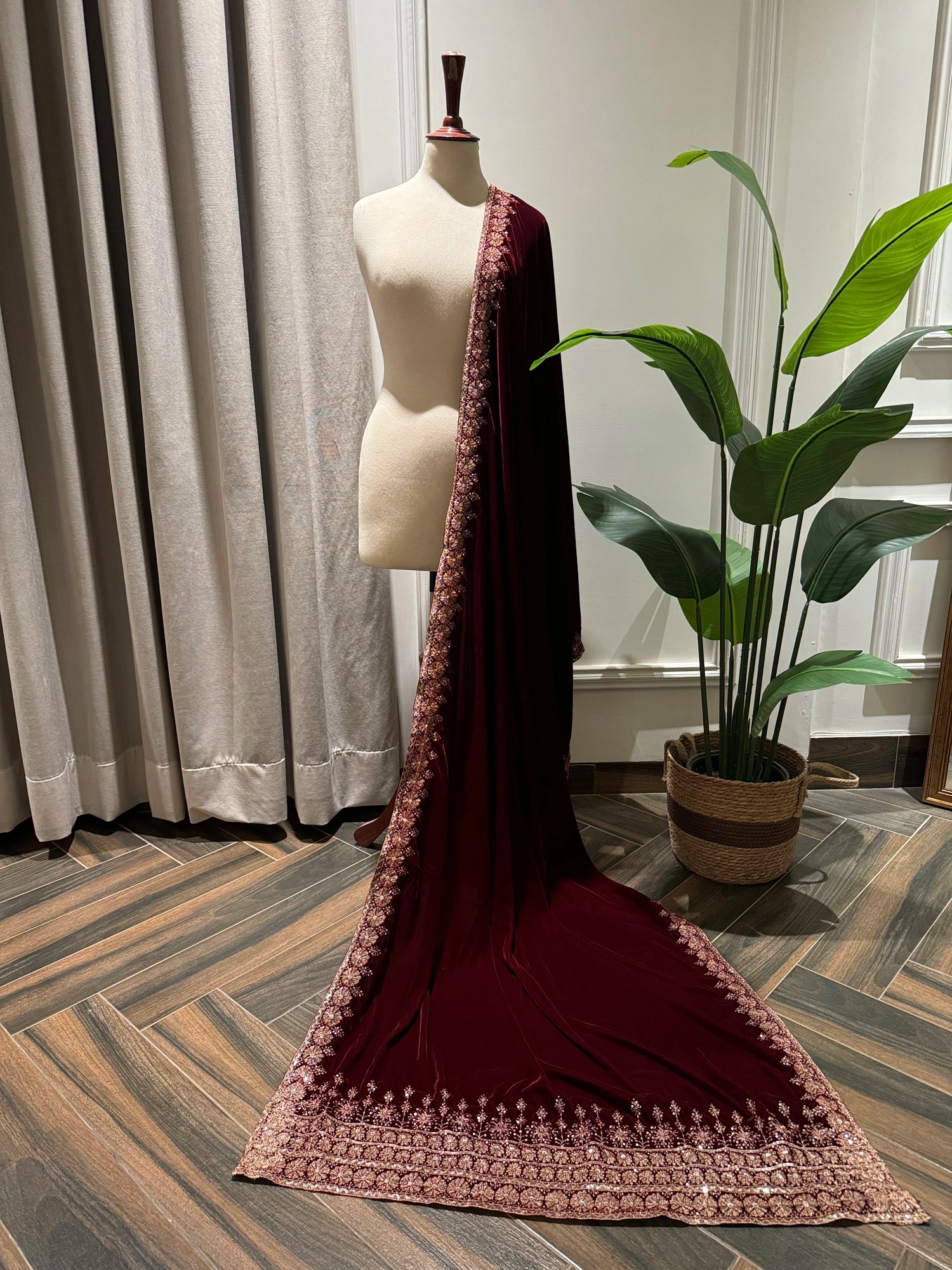 Exquisite deep maroon velvet shawl with wide antique gold tilla embroidery and sequins forming intricate floral motifs along scalloped edges, perfect for formal winter occasions.