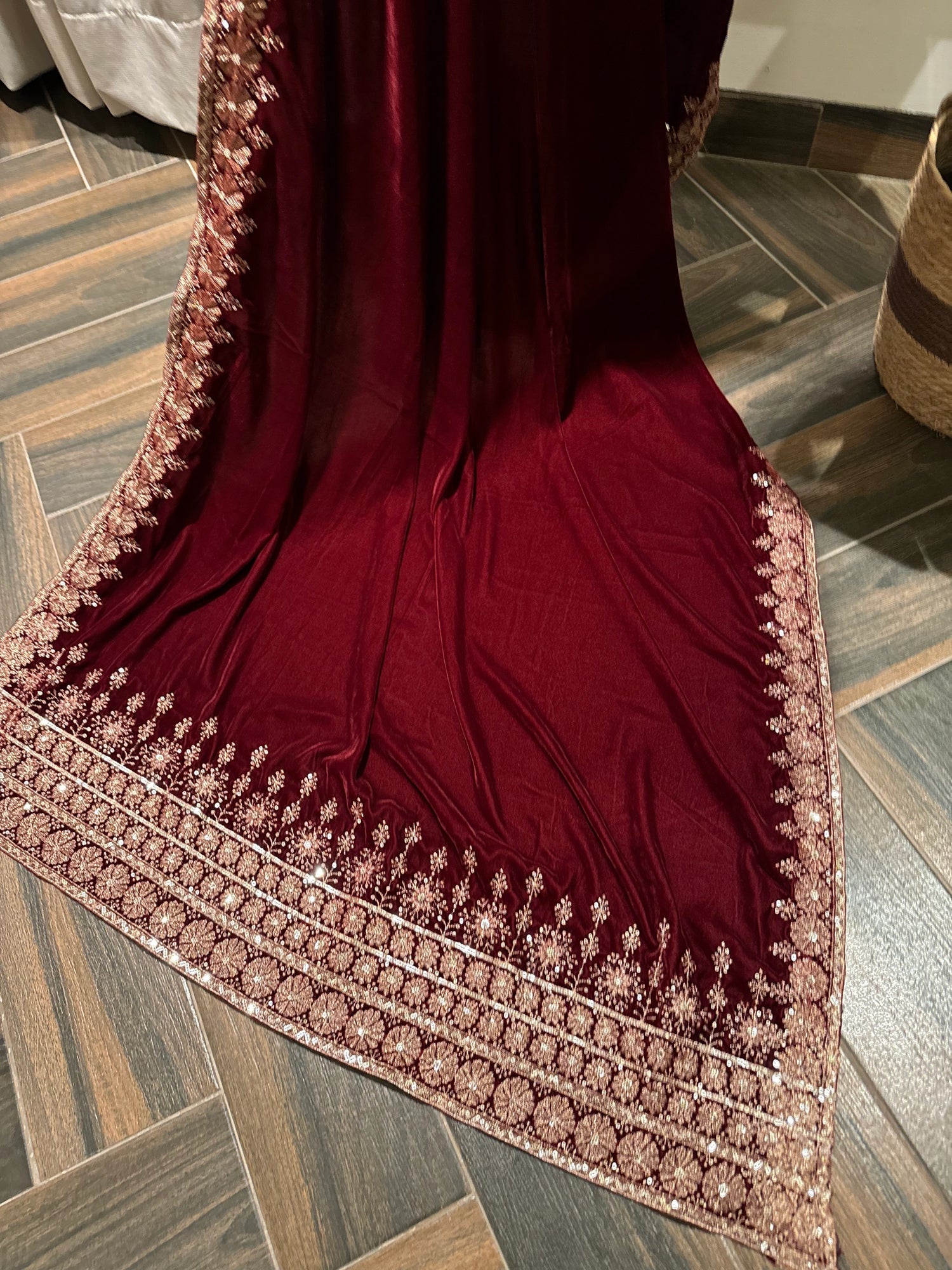 Exquisite deep maroon velvet shawl with wide antique gold tilla embroidery and sequins forming intricate floral motifs along scalloped edges, perfect for formal winter occasions.