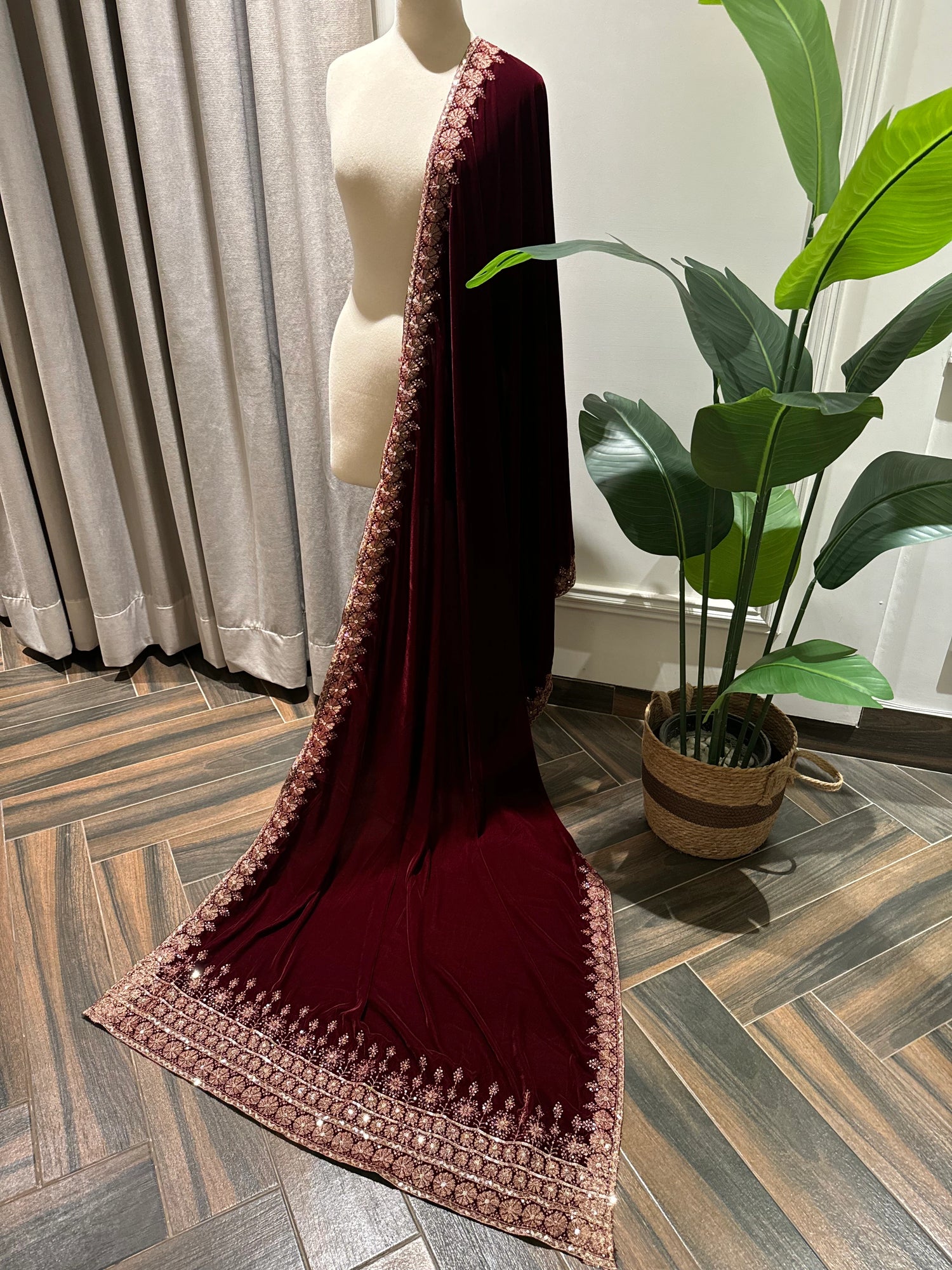 Exquisite deep maroon velvet shawl with wide antique gold tilla embroidery and sequins forming intricate floral motifs along scalloped edges, perfect for formal winter occasions.