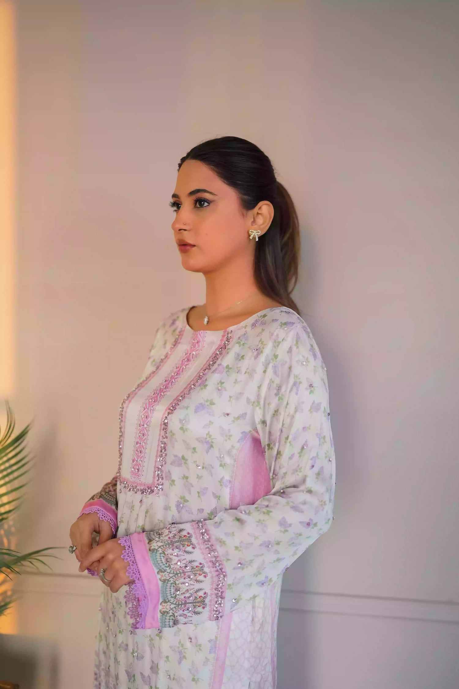 A luminous white kurta adorned with delicate lilac florals and subtle leafy accents. Fine detailing at the neckline adds understated opulence, while ornamental borders lead into a softly scalloped lilac edge. This piece feel effortlessly refined for daytime celebrations, Eid or elegant evening wear.
