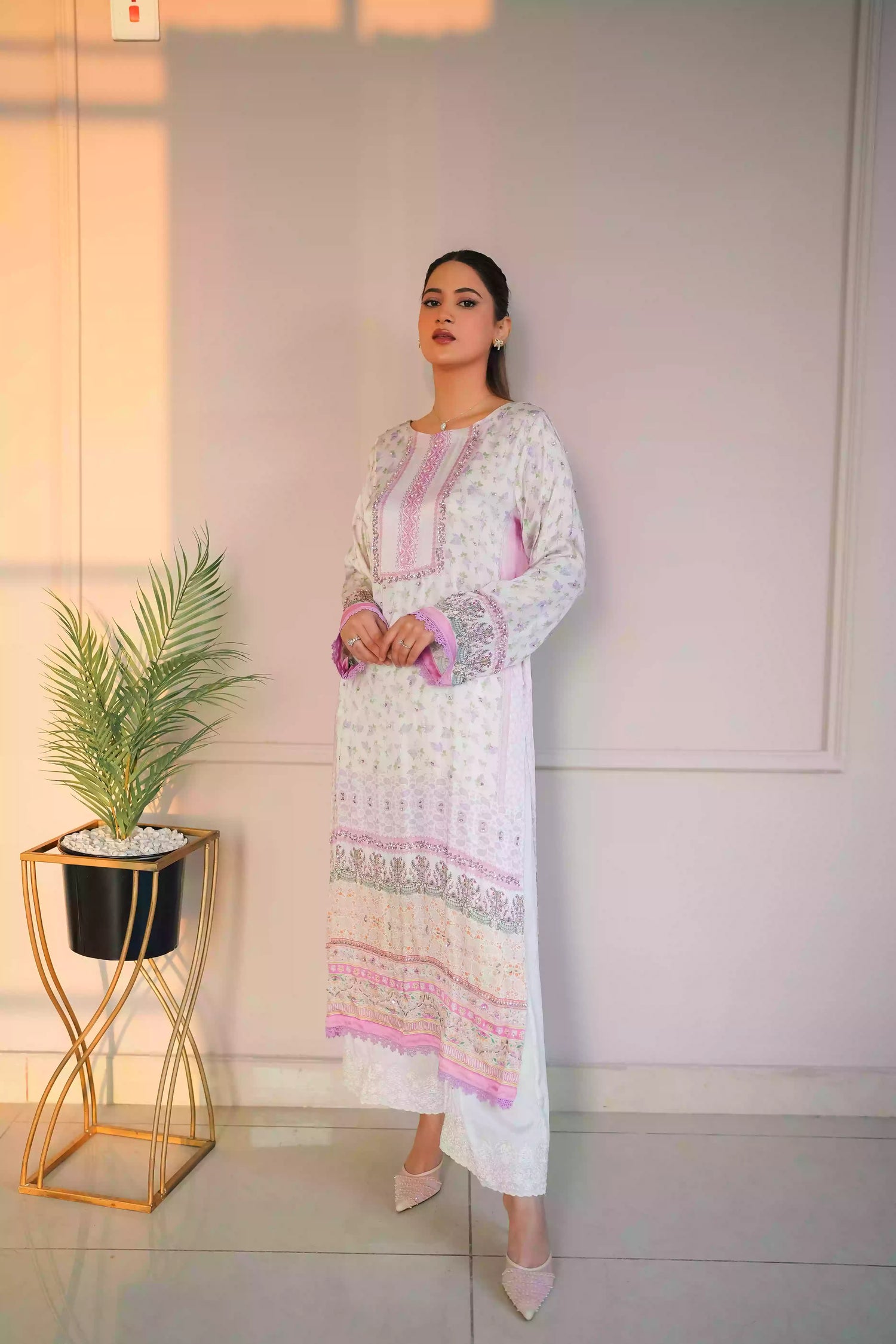 A luminous white kurta adorned with delicate lilac florals and subtle leafy accents. Fine detailing at the neckline adds understated opulence, while ornamental borders lead into a softly scalloped lilac edge. This piece feel effortlessly refined for daytime celebrations, Eid or elegant evening wear.