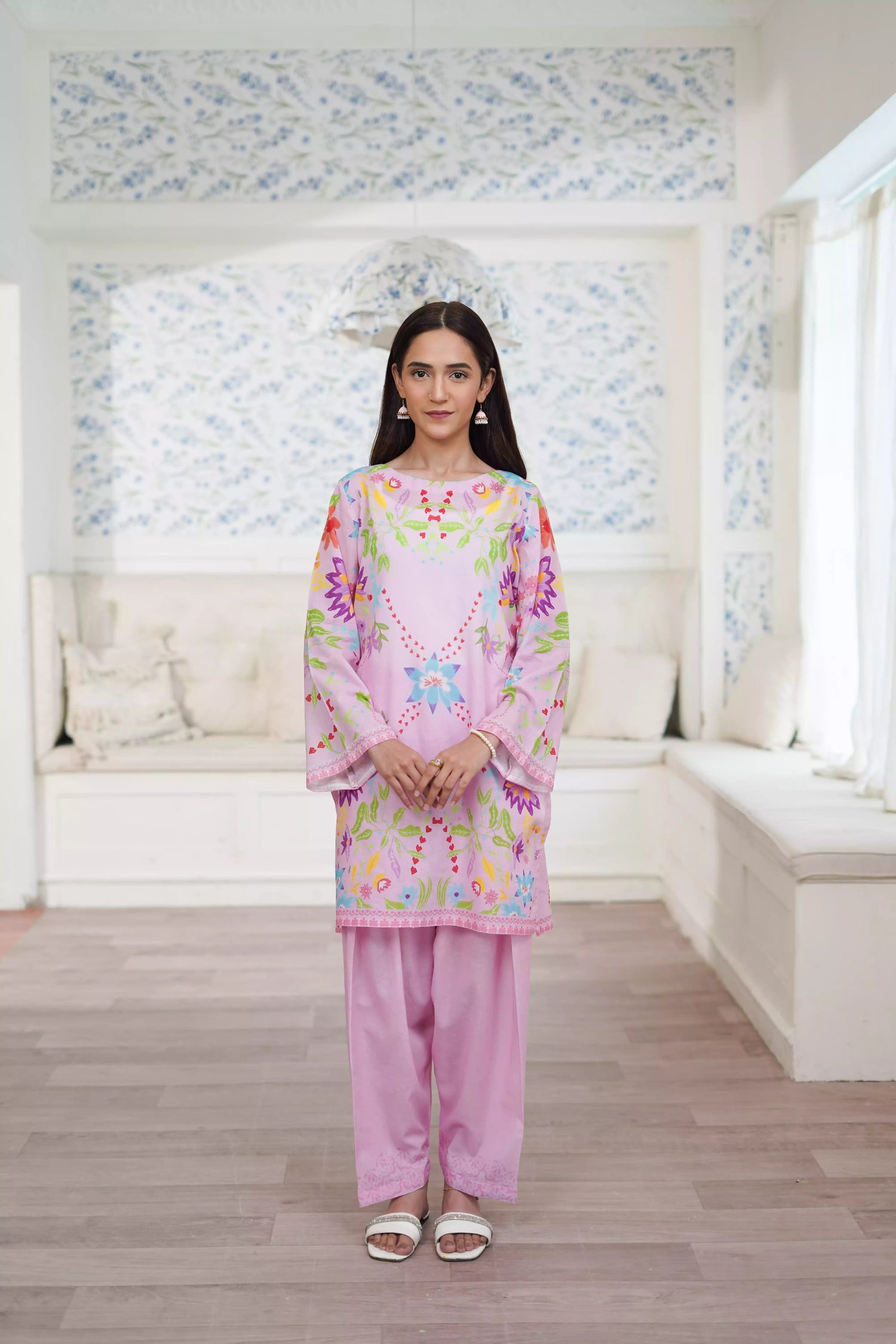 Blush pink cord set featuring a straight-cut shirt with symmetrical wildflower and botanical prints, paired with plain pink trousers, adds elegance to this minimalist floral ensemble.