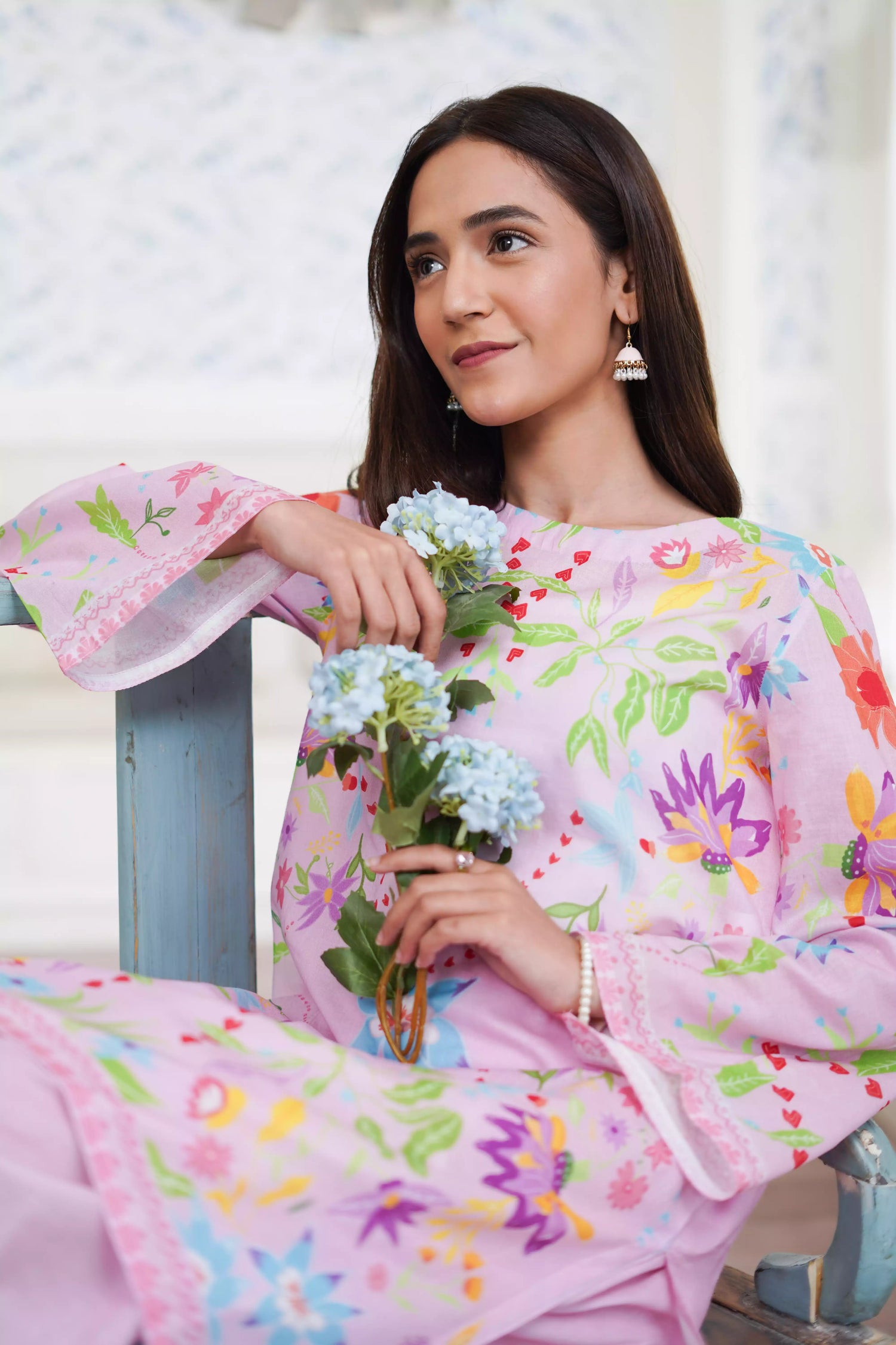 Blush pink cord set featuring a straight-cut shirt with symmetrical wildflower and botanical prints, paired with plain pink trousers, adds elegance to this minimalist floral ensemble.