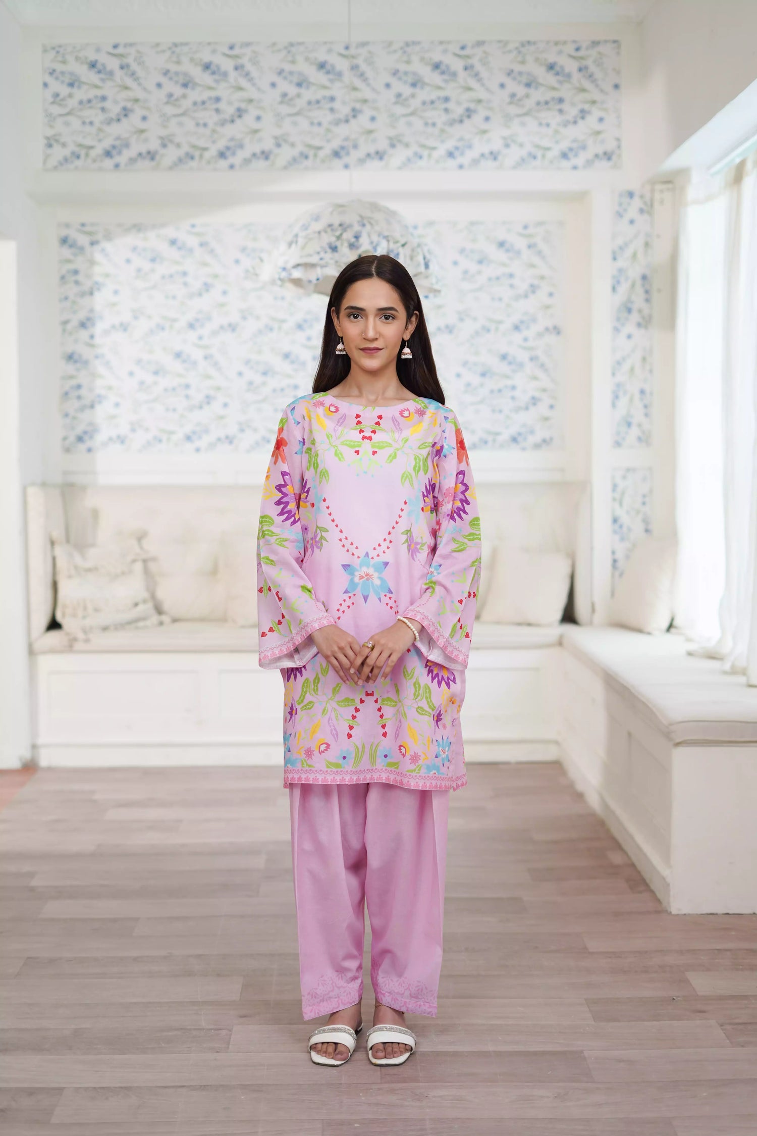 Blush pink cord set featuring a straight-cut shirt with symmetrical wildflower and botanical prints, paired with plain pink trousers, adds elegance to this minimalist floral ensemble.