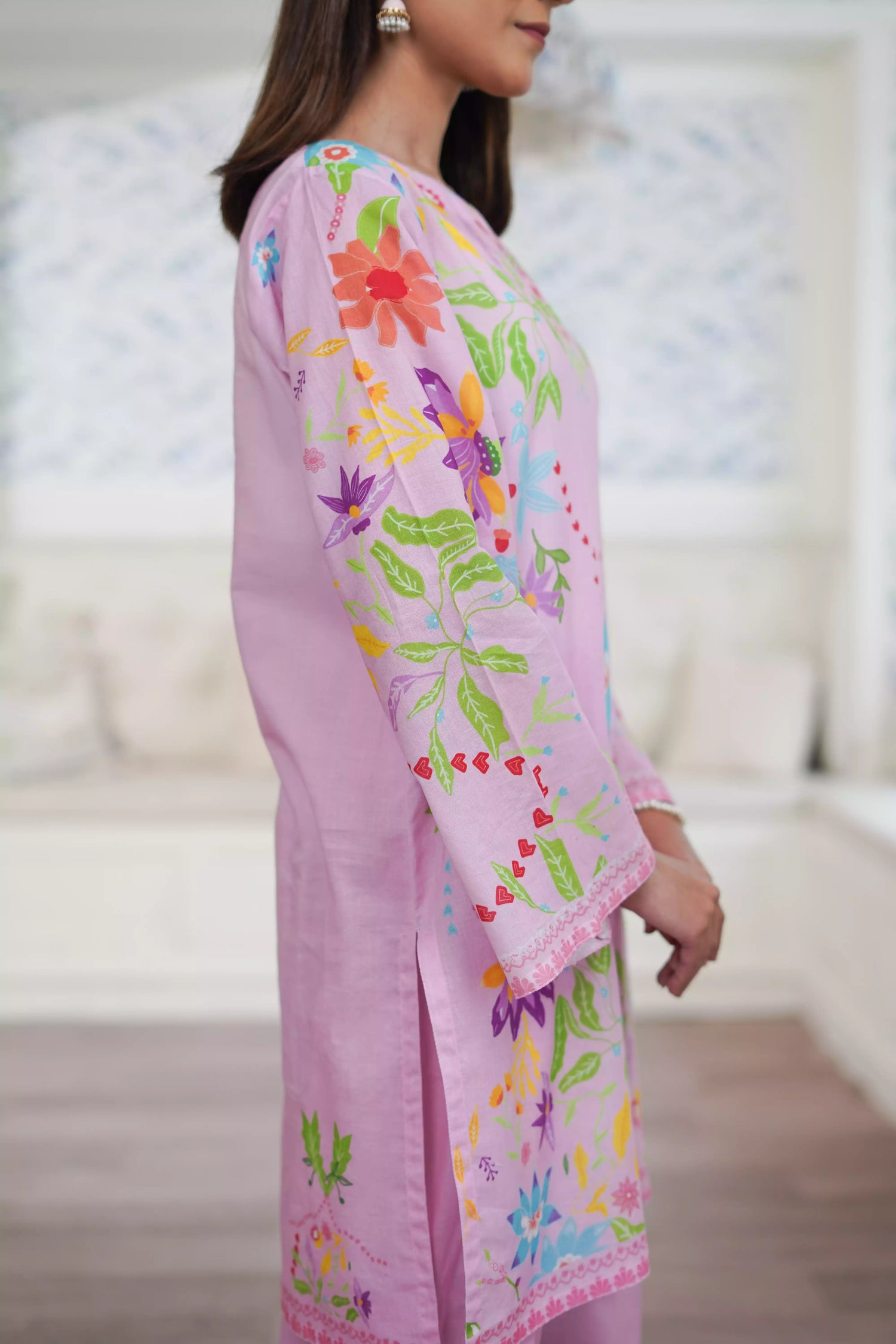 Blush pink cord set featuring a straight-cut shirt with symmetrical wildflower and botanical prints, paired with plain pink trousers, adds elegance to this minimalist floral ensemble.