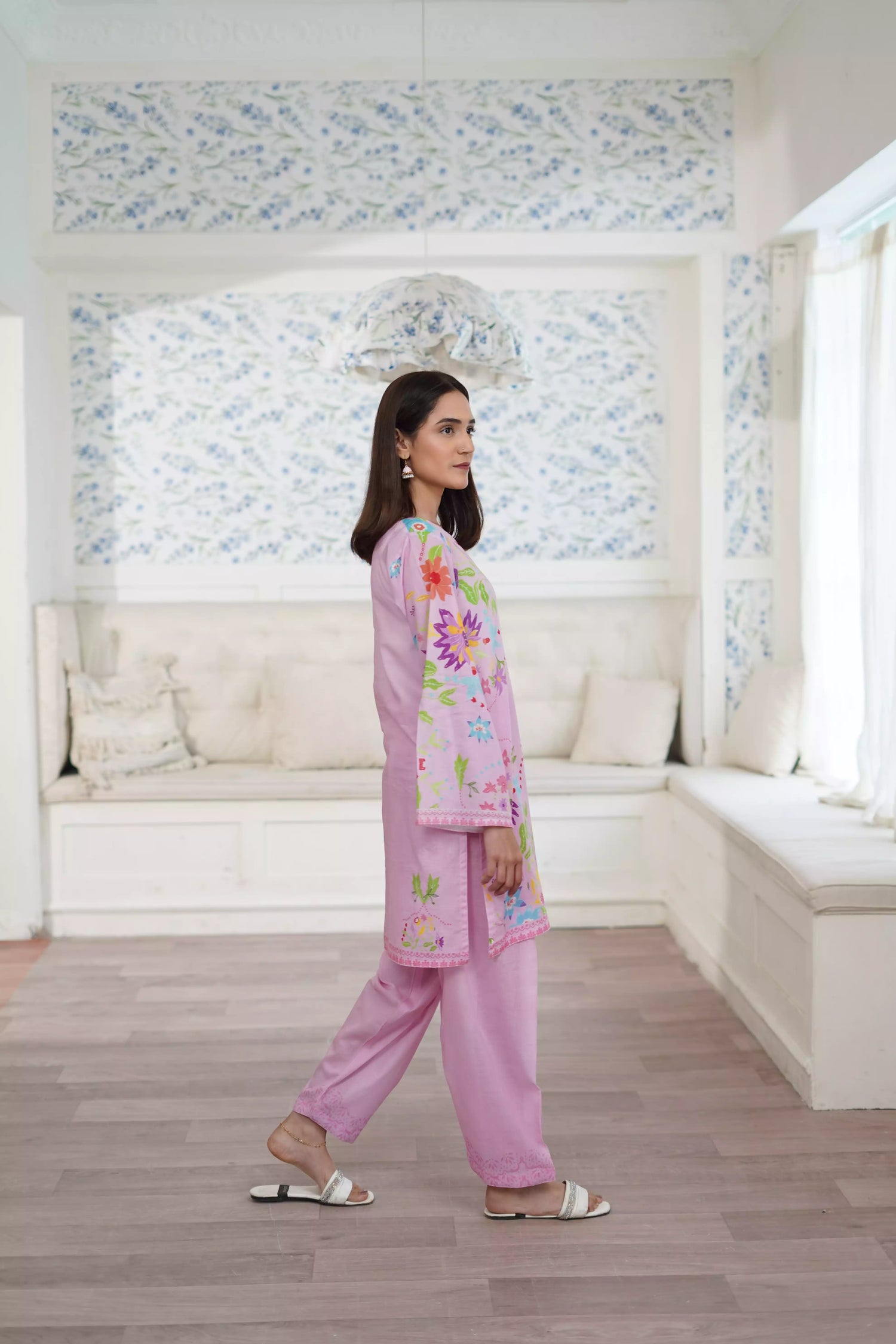 Blush pink cord set featuring a straight-cut shirt with symmetrical wildflower and botanical prints, paired with plain pink trousers, adds elegance to this minimalist floral ensemble.