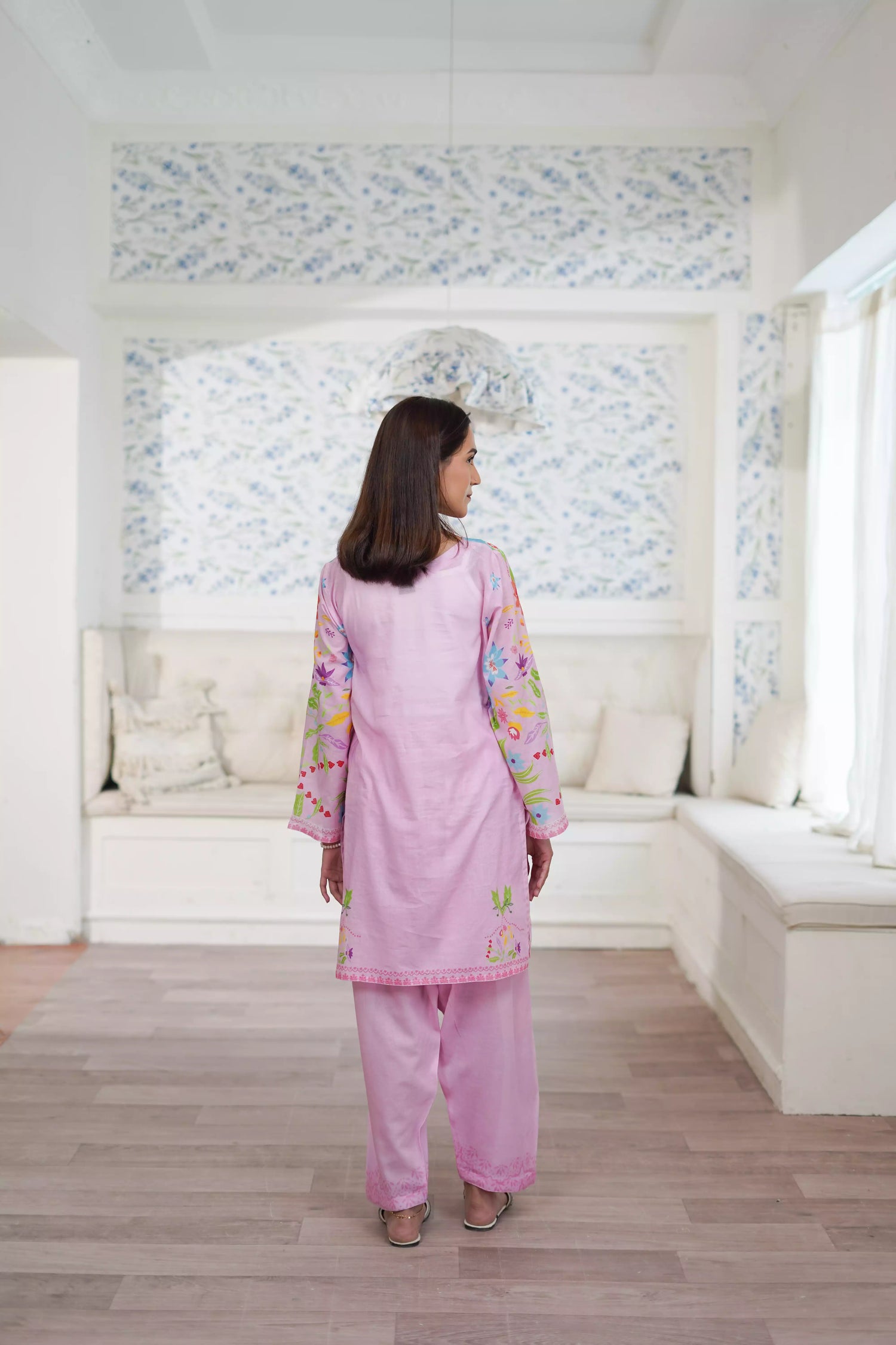 Blush pink cord set featuring a straight-cut shirt with symmetrical wildflower and botanical prints, paired with plain pink trousers, adds elegance to this minimalist floral ensemble.