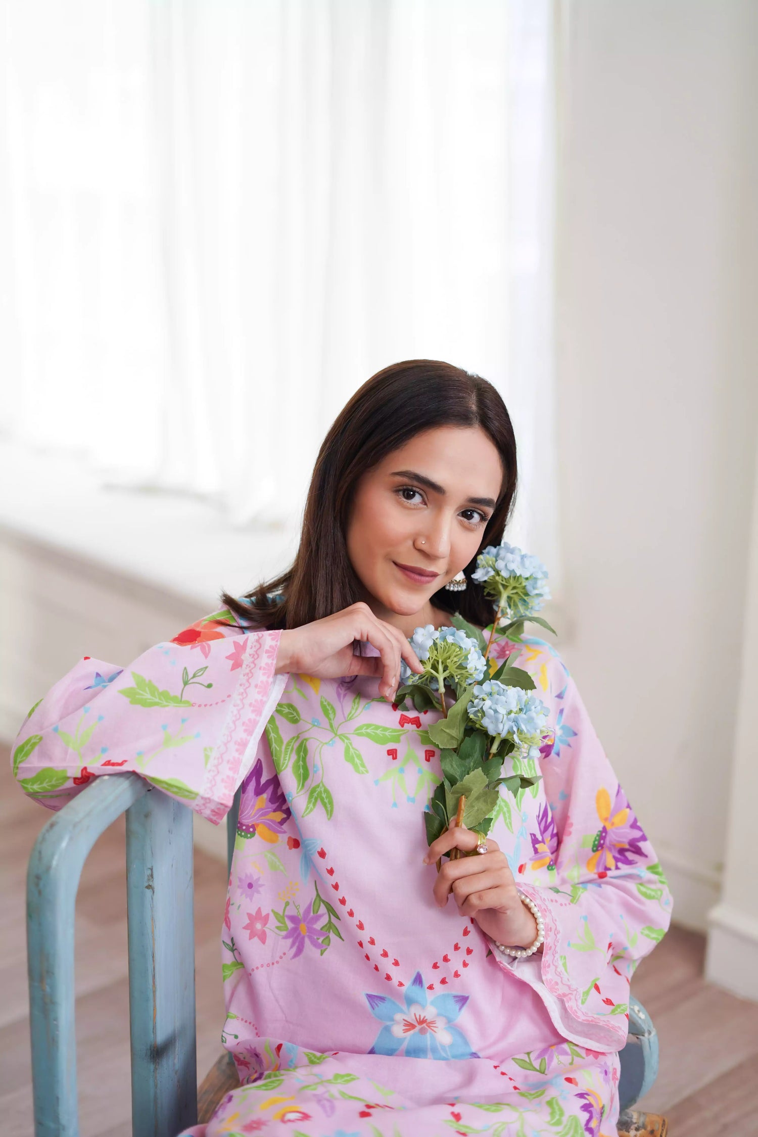 Blush pink cord set featuring a straight-cut shirt with symmetrical wildflower and botanical prints, paired with plain pink trousers, adds elegance to this minimalist floral ensemble.