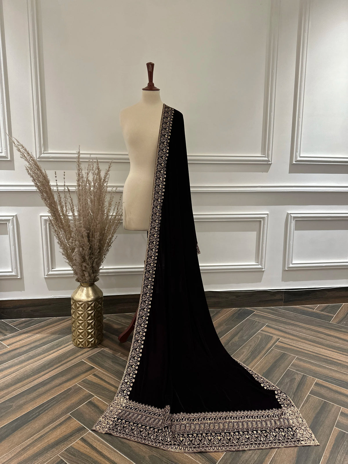 Elegant black velvet shawl with heavy gold tilla border and intricate gold floral embroidery, perfect for weddings, Eid, or festive occasions.