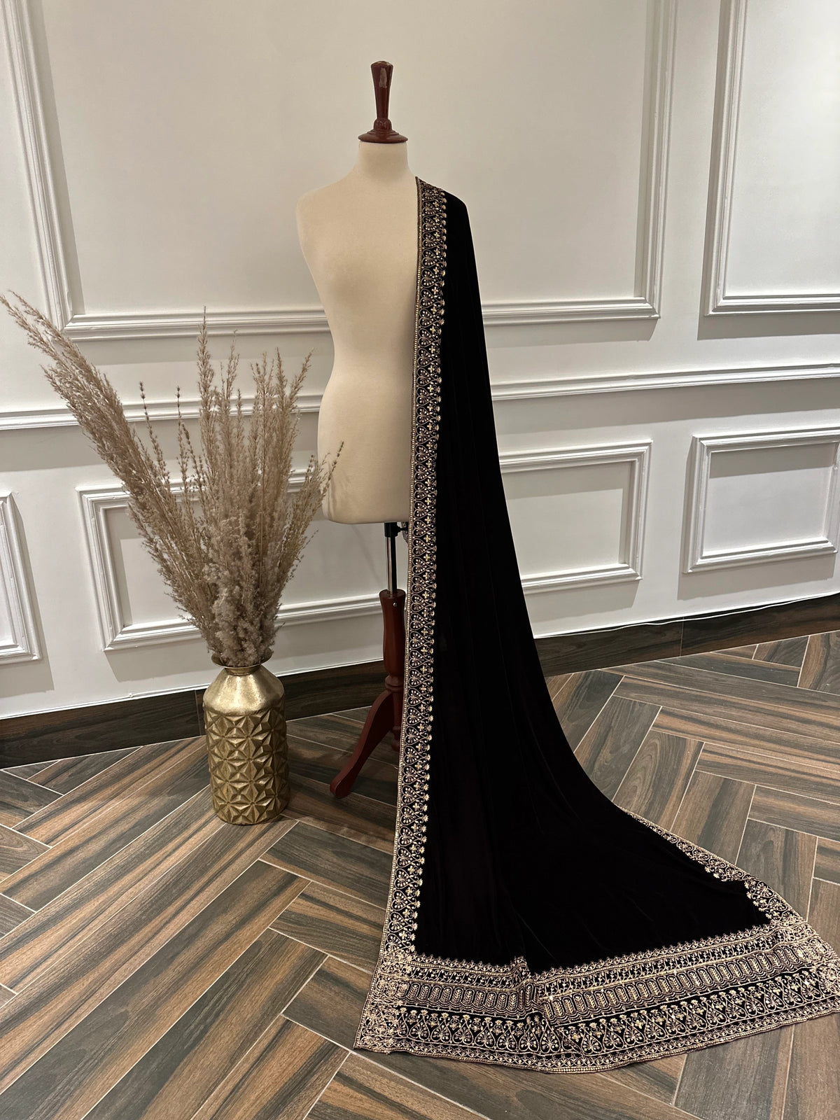 Elegant black velvet shawl with heavy gold tilla border and intricate gold floral embroidery, perfect for weddings, Eid, or festive occasions.