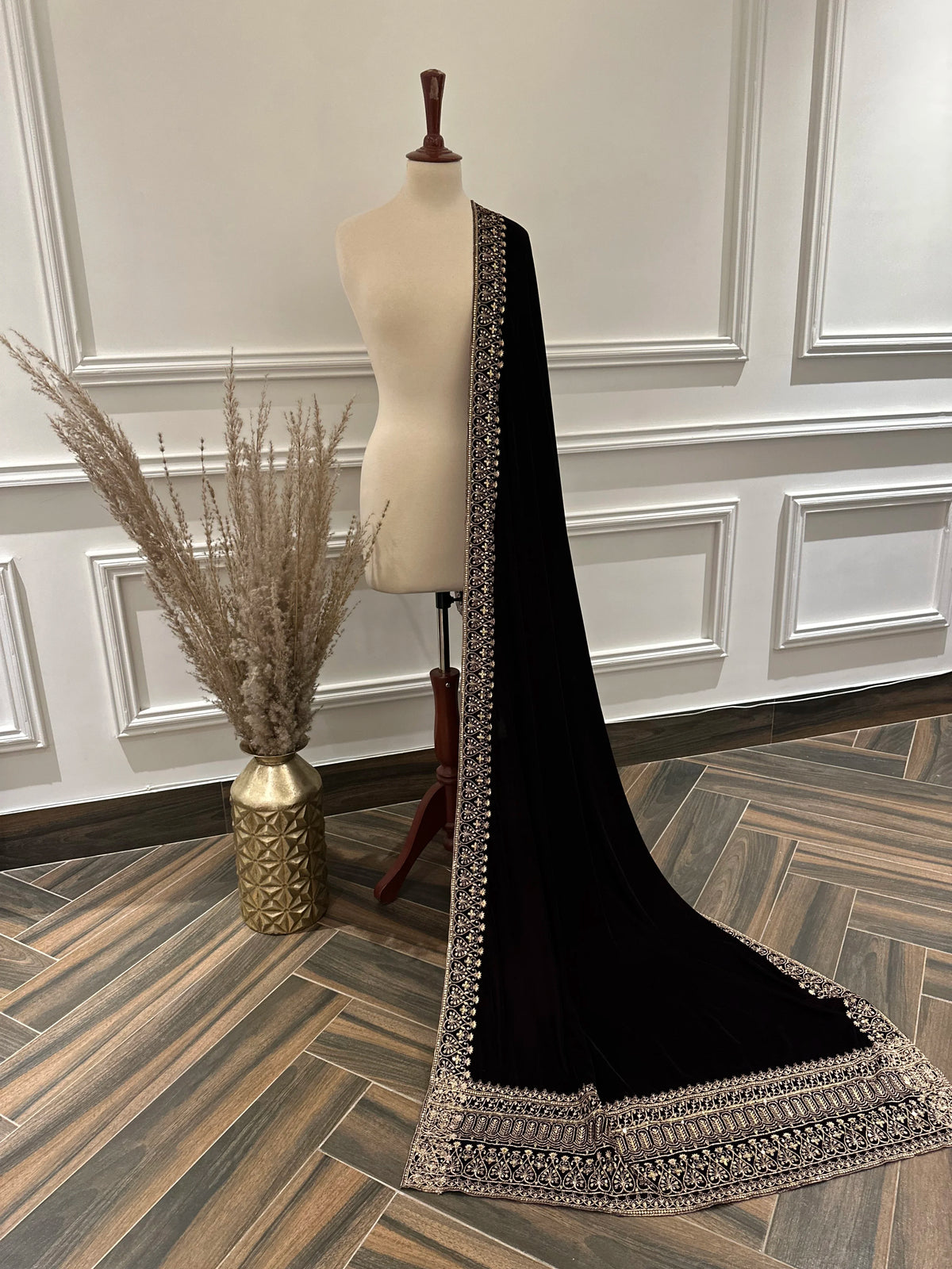 Elegant black velvet shawl with heavy gold tilla border and intricate gold floral embroidery, perfect for weddings, Eid, or festive occasions.