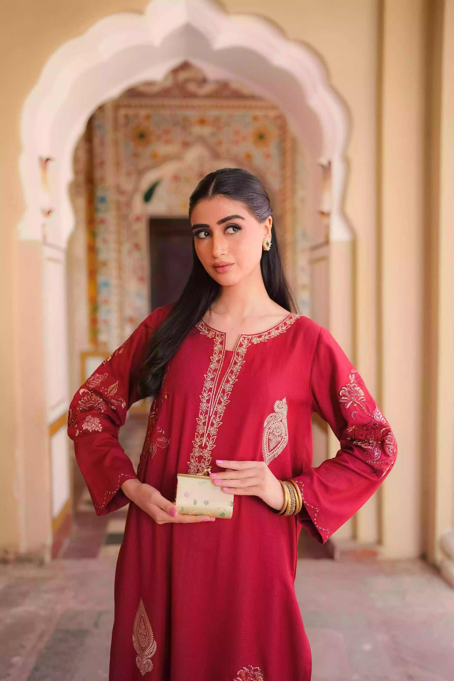 An embroidered suit with delicate motifs and subtle threadwork along the borders. The look is paired with a beautifully adorned trouser accented with a rich hint of red, creating a warm, festive appearance ideal for celebrations and winter gatherings.