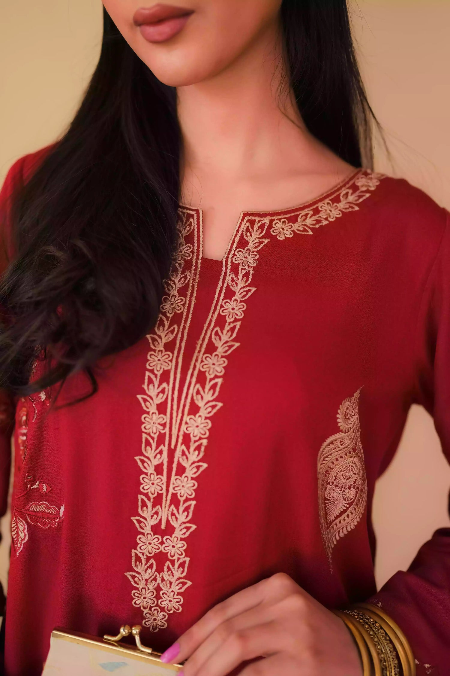 An embroidered suit with delicate motifs and subtle threadwork along the borders. The look is paired with a beautifully adorned trouser accented with a rich hint of red, creating a warm, festive appearance ideal for celebrations and winter gatherings.