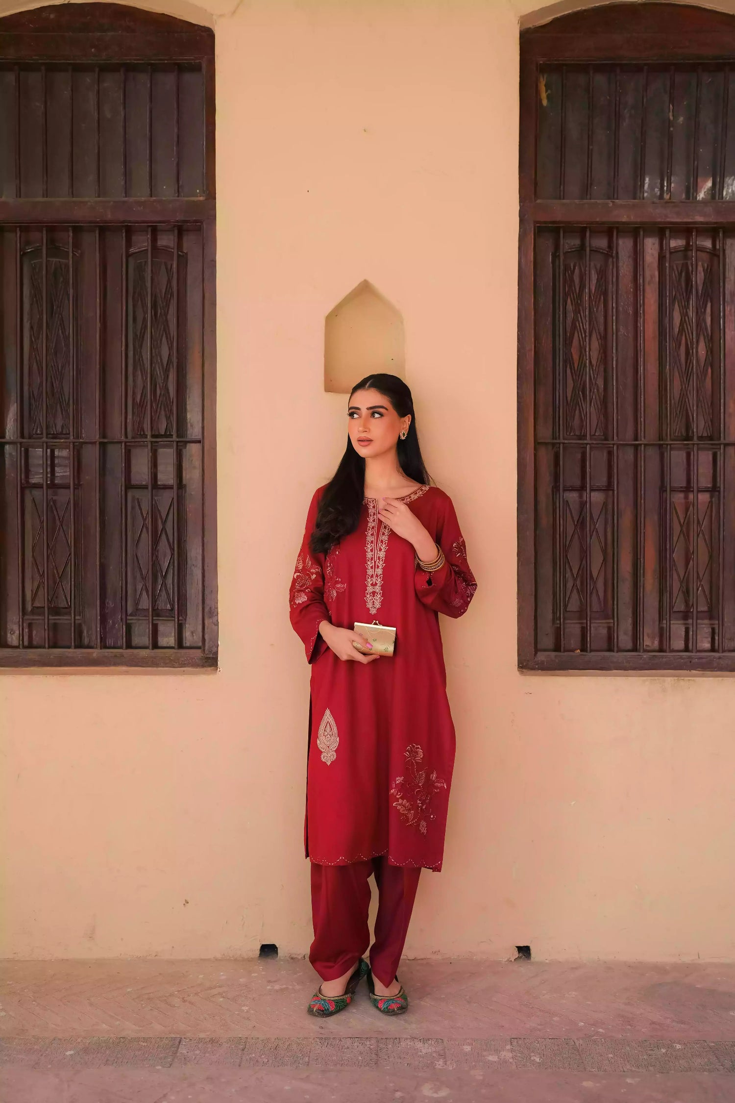 An embroidered suit with delicate motifs and subtle threadwork along the borders. The look is paired with a beautifully adorned trouser accented with a rich hint of red, creating a warm, festive appearance ideal for celebrations and winter gatherings.