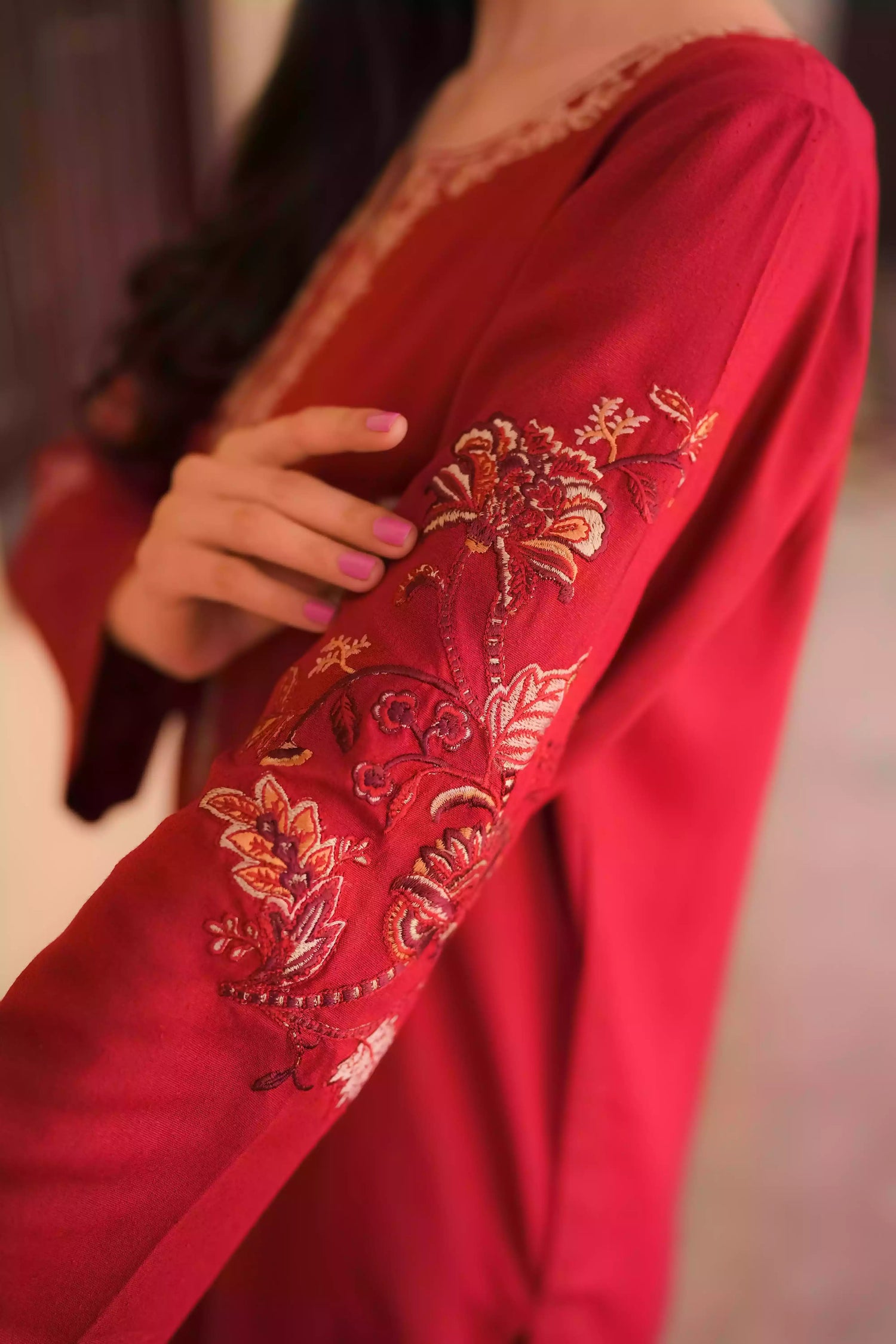 An embroidered suit with delicate motifs and subtle threadwork along the borders. The look is paired with a beautifully adorned trouser accented with a rich hint of red, creating a warm, festive appearance ideal for celebrations and winter gatherings.