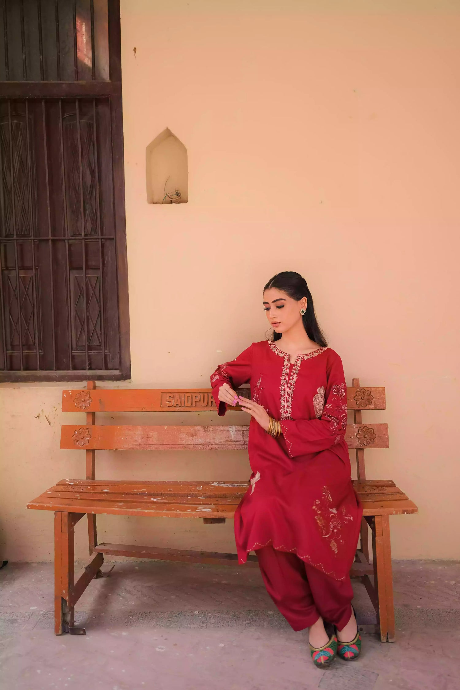 An embroidered suit with delicate motifs and subtle threadwork along the borders. The look is paired with a beautifully adorned trouser accented with a rich hint of red, creating a warm, festive appearance ideal for celebrations and winter gatherings.