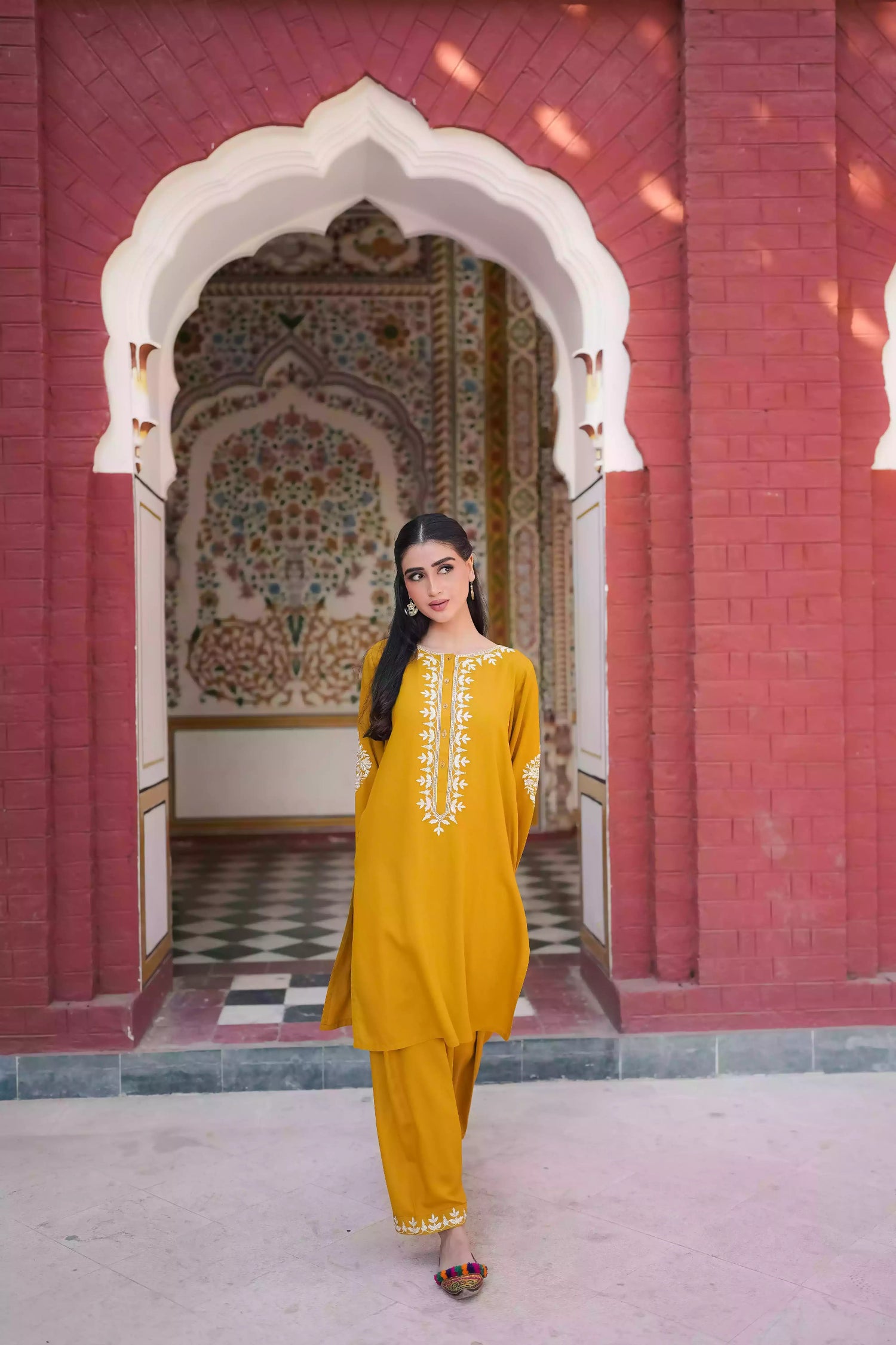 Mustard yellow embroidered kurta, featuring soft, flowing fabric with delicate white floral embroidery paired with a shalwar detailed with subtle threadwork. Styled for modern, festive, or daytime wear.