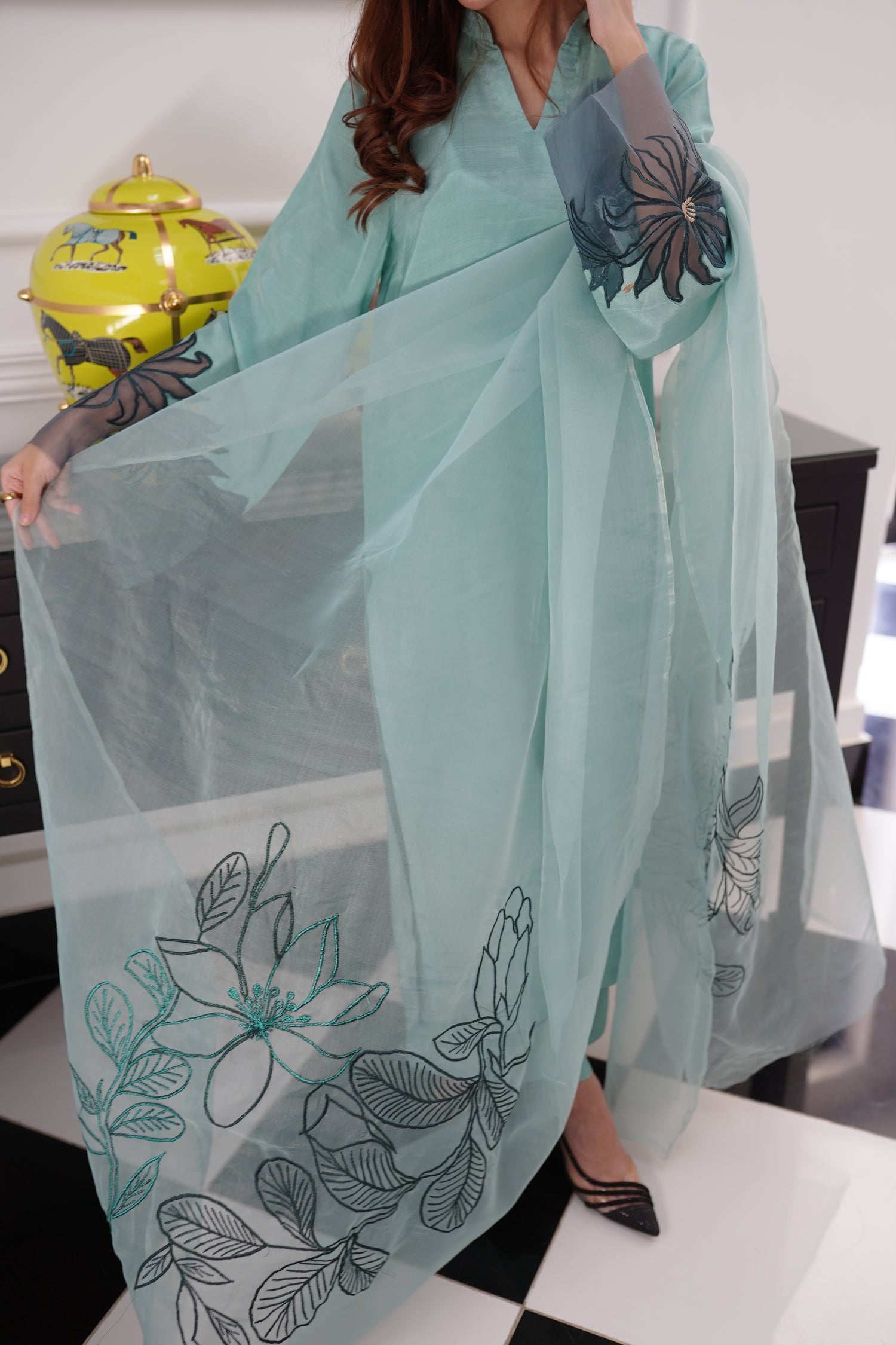 Mint green dress with contrasting green organza sleeves featuring intricate cutwork floral embroidery, blending soft elegance with nature-inspired design.