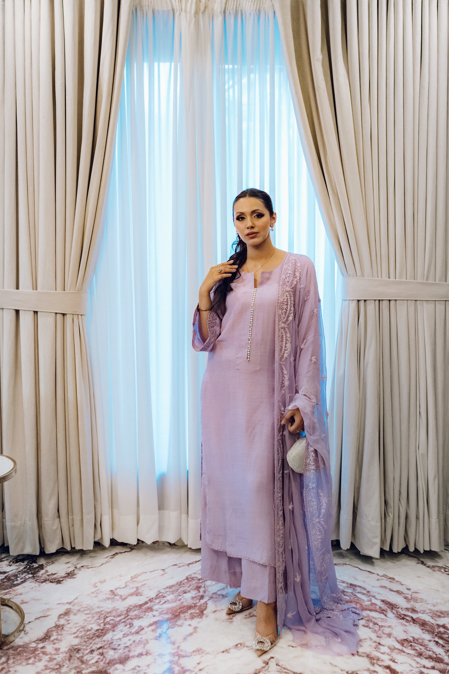 Lilac long shirt with pearl-buttoned neckline, lace-detailed hem, and embroidered sleeves, paired with a chiffon dupatta featuring matching floral embroidery for ethereal look.