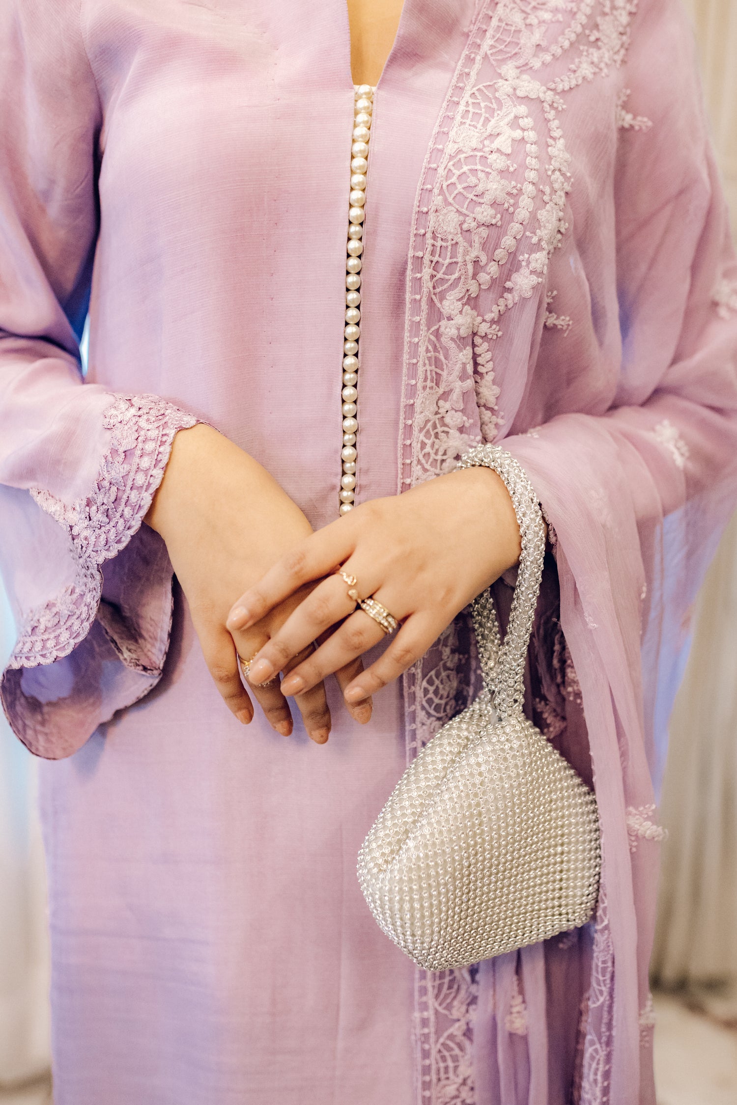 Lilac long shirt with pearl-buttoned neckline, lace-detailed hem, and embroidered sleeves, paired with a chiffon dupatta featuring matching floral embroidery for ethereal look.