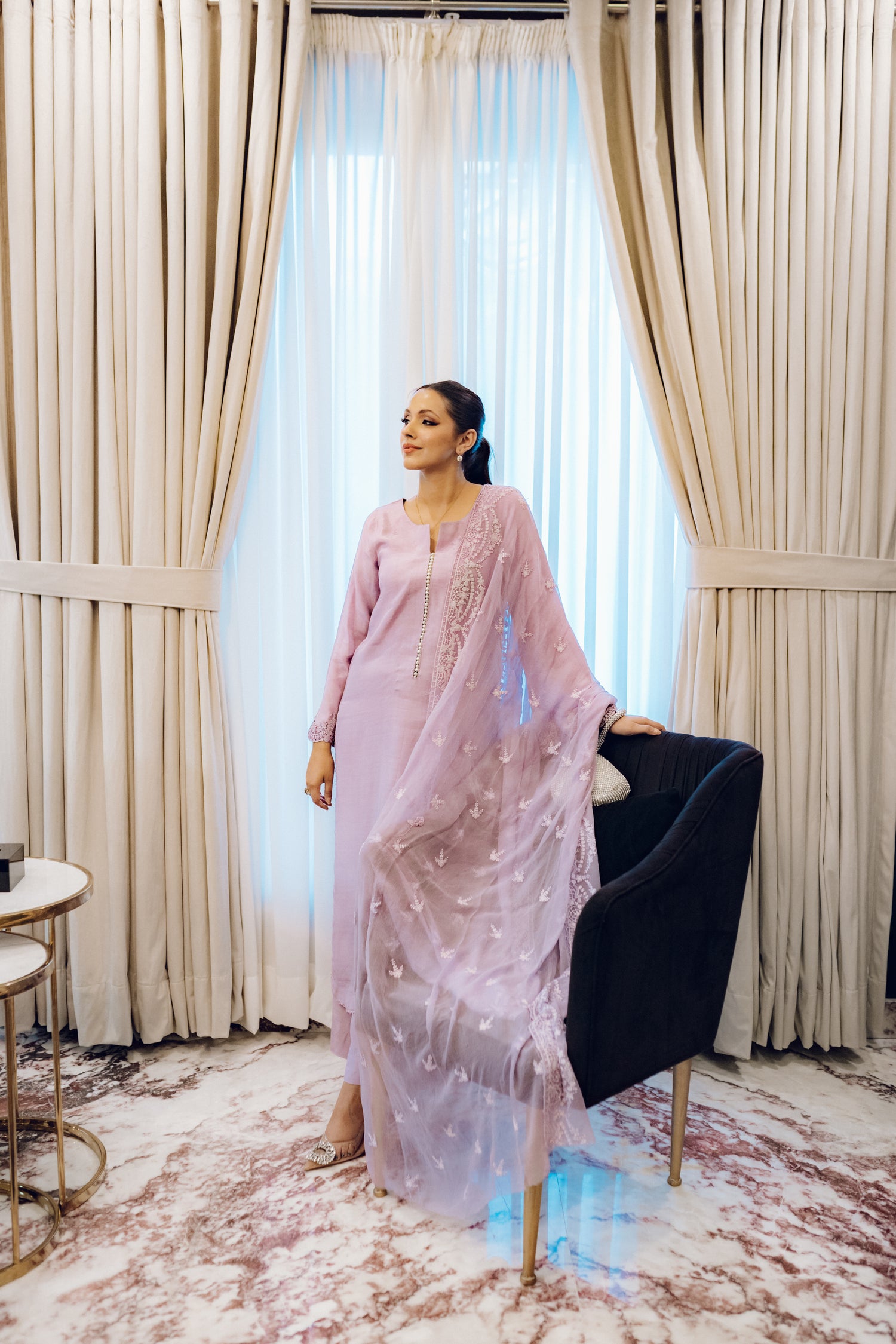 Lilac long shirt with pearl-buttoned neckline, lace-detailed hem, and embroidered sleeves, paired with a chiffon dupatta featuring matching floral embroidery for ethereal look.