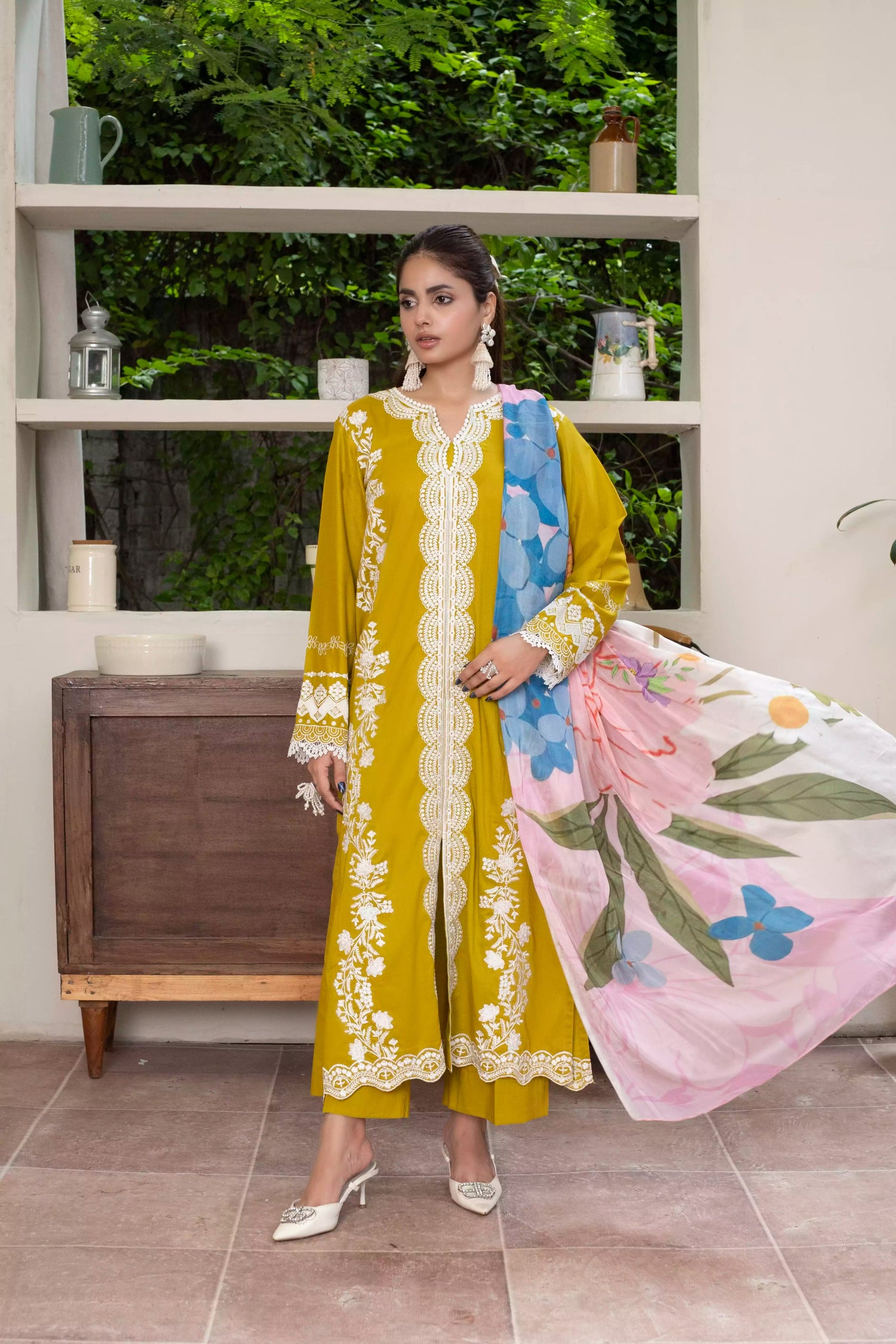 A beautiful mustard embroidered suit with white floral detailing, paired with a vibrant silk dupatta, ideal for festive events.