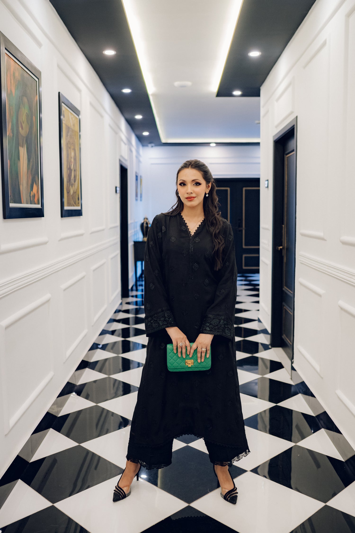 A sophisticated black embroidered dress with intricate motifs and lace detailing, paired with an organza dupatta featuring coordinated embroidery for an elegant look.