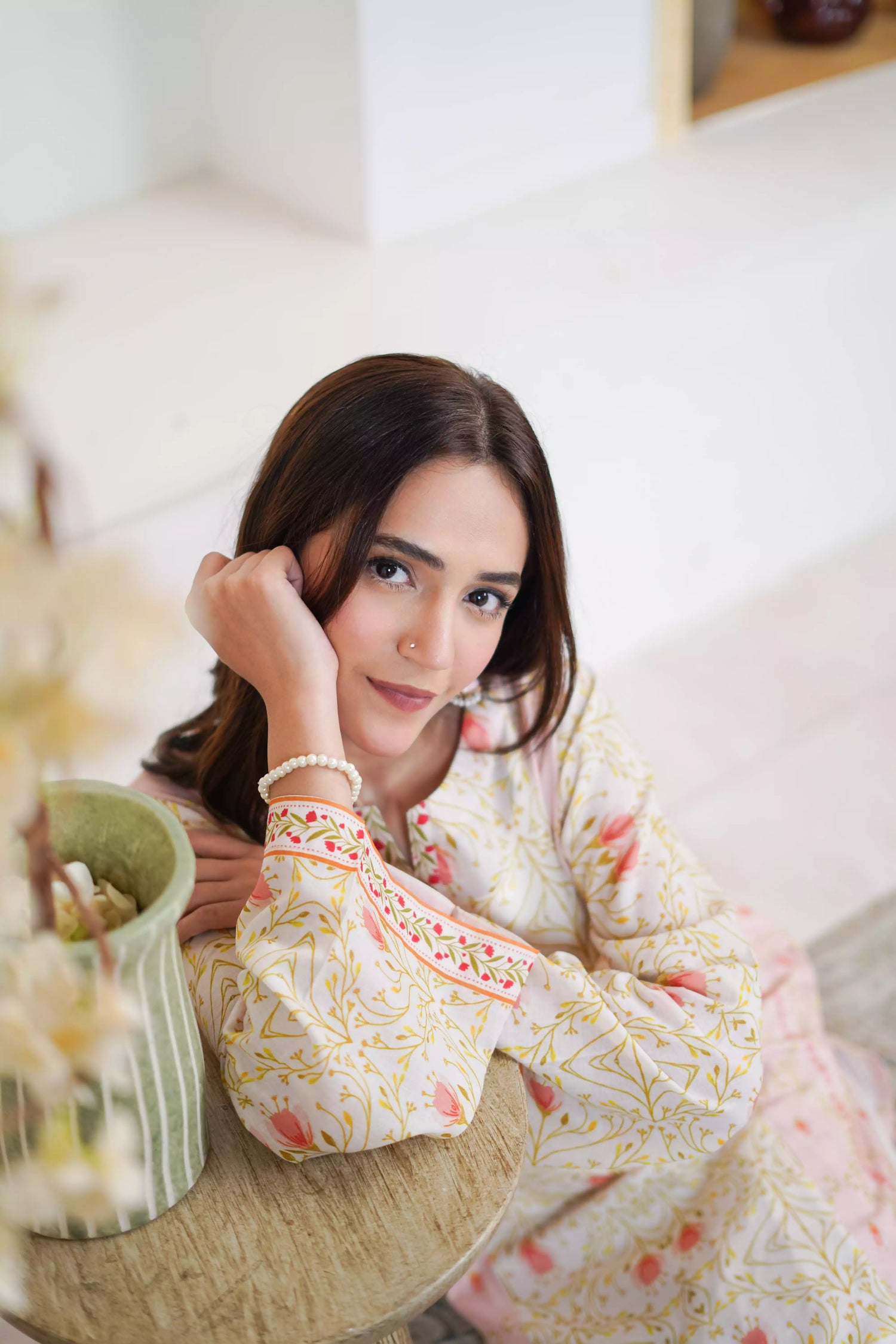 Elegant floral print with pink tulips and green vines on soft pastel fabric. Features fine borders and a graceful, symmetrical design for festive or casual wear.