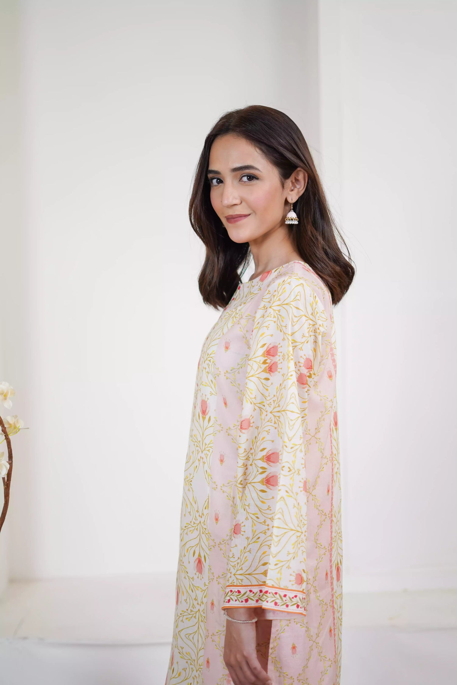 Elegant floral print with pink tulips and green vines on soft pastel fabric. Features fine borders and a graceful, symmetrical design for festive or casual wear.