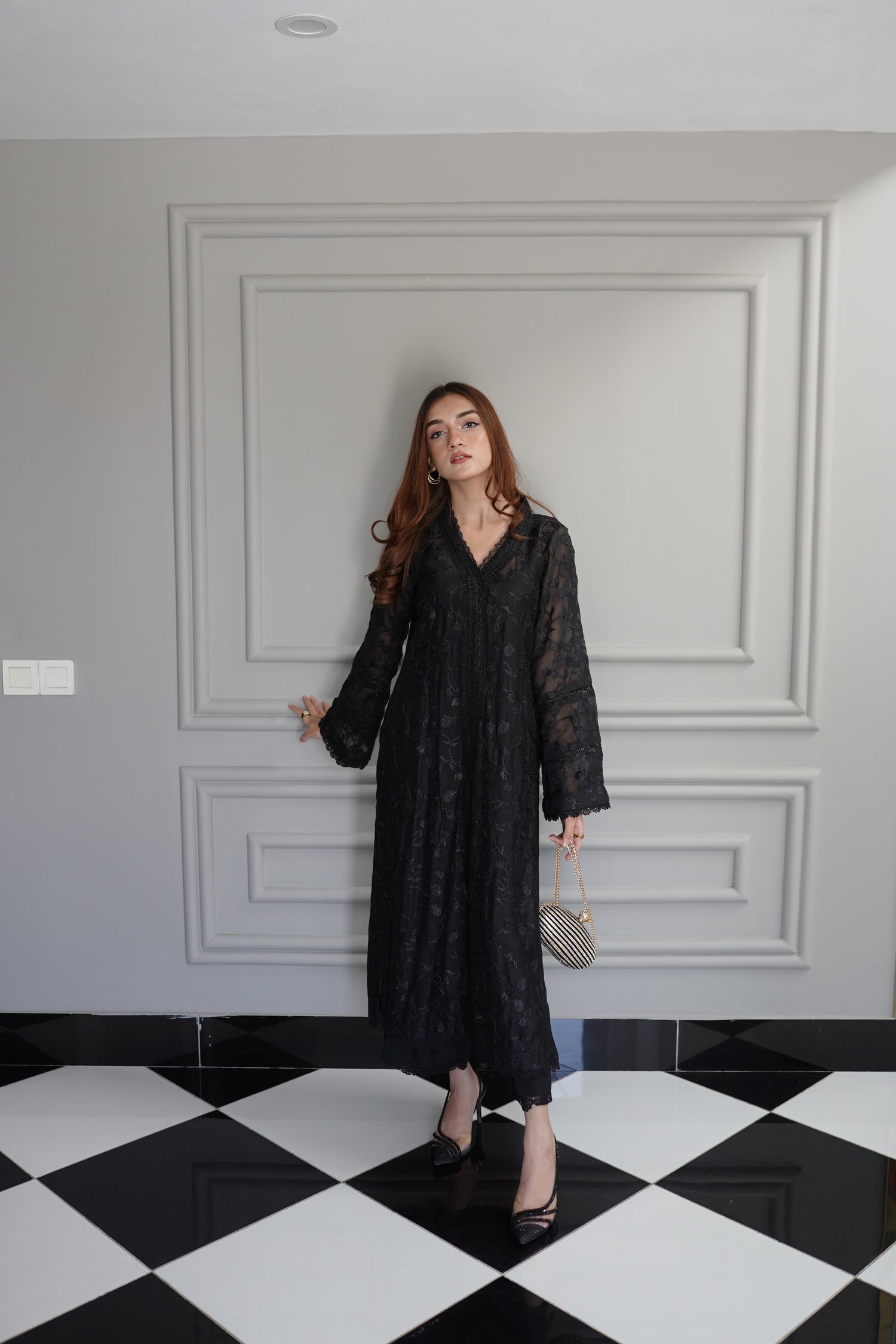 Black embroidered raw silk dress with lace-detailed neckline and sleeves, paired with matching flared pants, showcasing sophisticated craftsmanship and cohesive design.