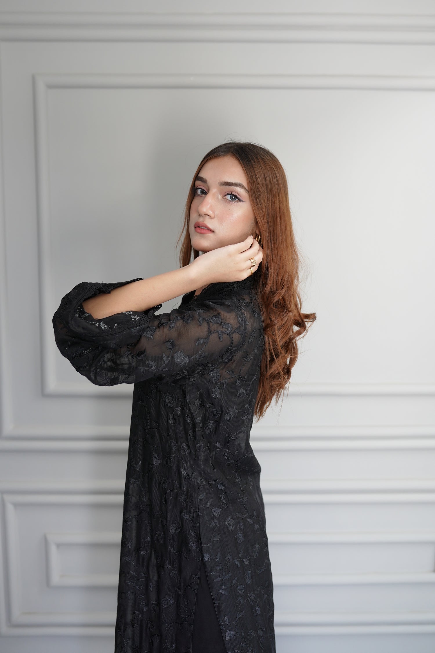 Black embroidered raw silk dress with lace-detailed neckline and sleeves, paired with matching flared pants, showcasing sophisticated craftsmanship and cohesive design.