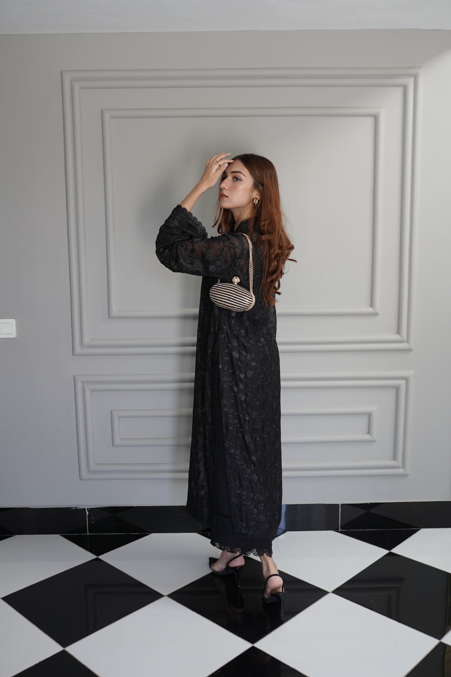 Black embroidered raw silk dress with lace-detailed neckline and sleeves, paired with matching flared pants, showcasing sophisticated craftsmanship and cohesive design.