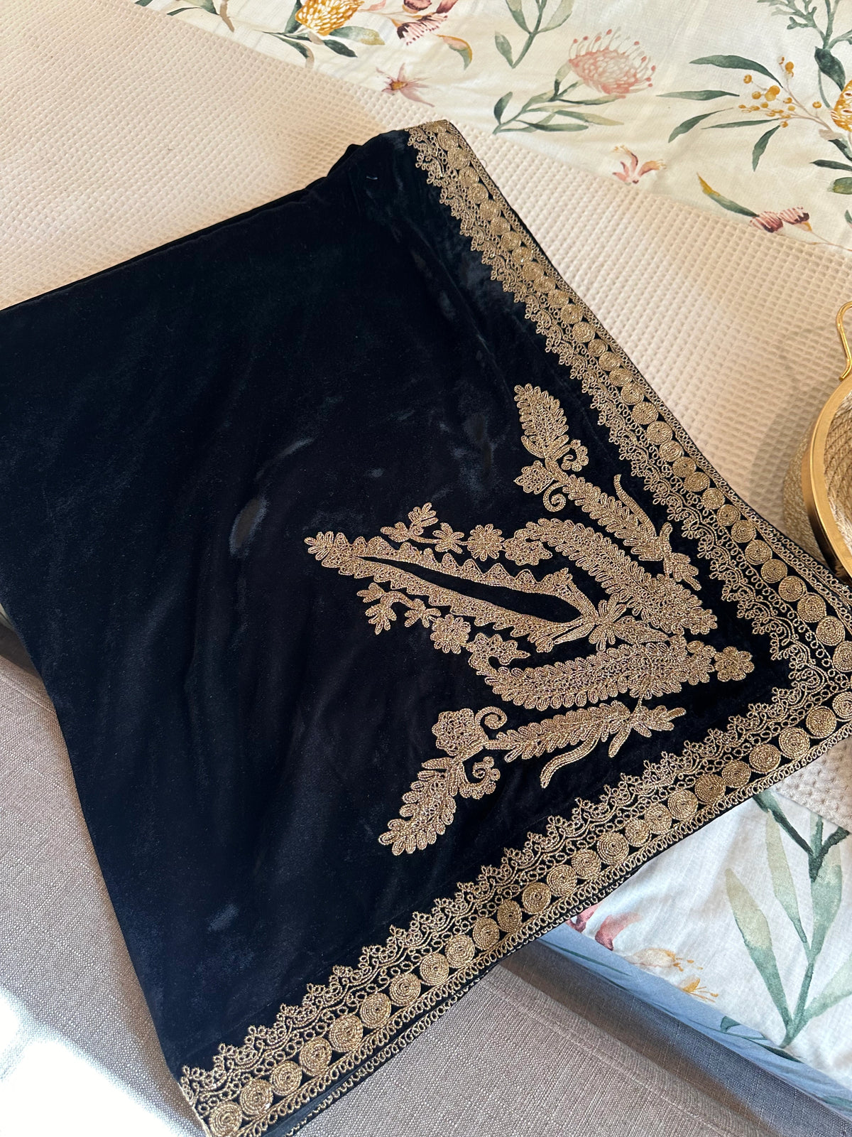 Luxurious black velvet shawl featuring detailed gold embroidery along the borders and corners, offering an elegant drape perfect for festive events and formal occasions.