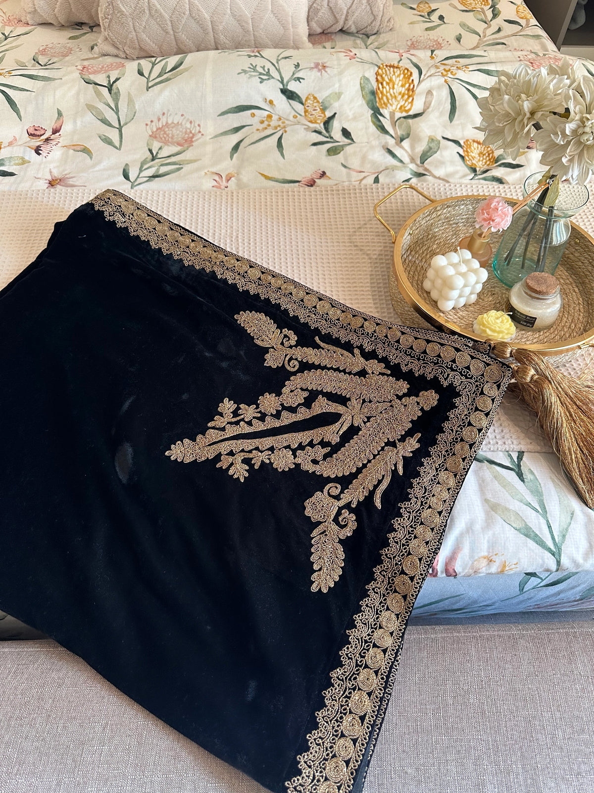 Luxurious black velvet shawl featuring detailed gold embroidery along the borders and corners, offering an elegant drape perfect for festive events and formal occasions.